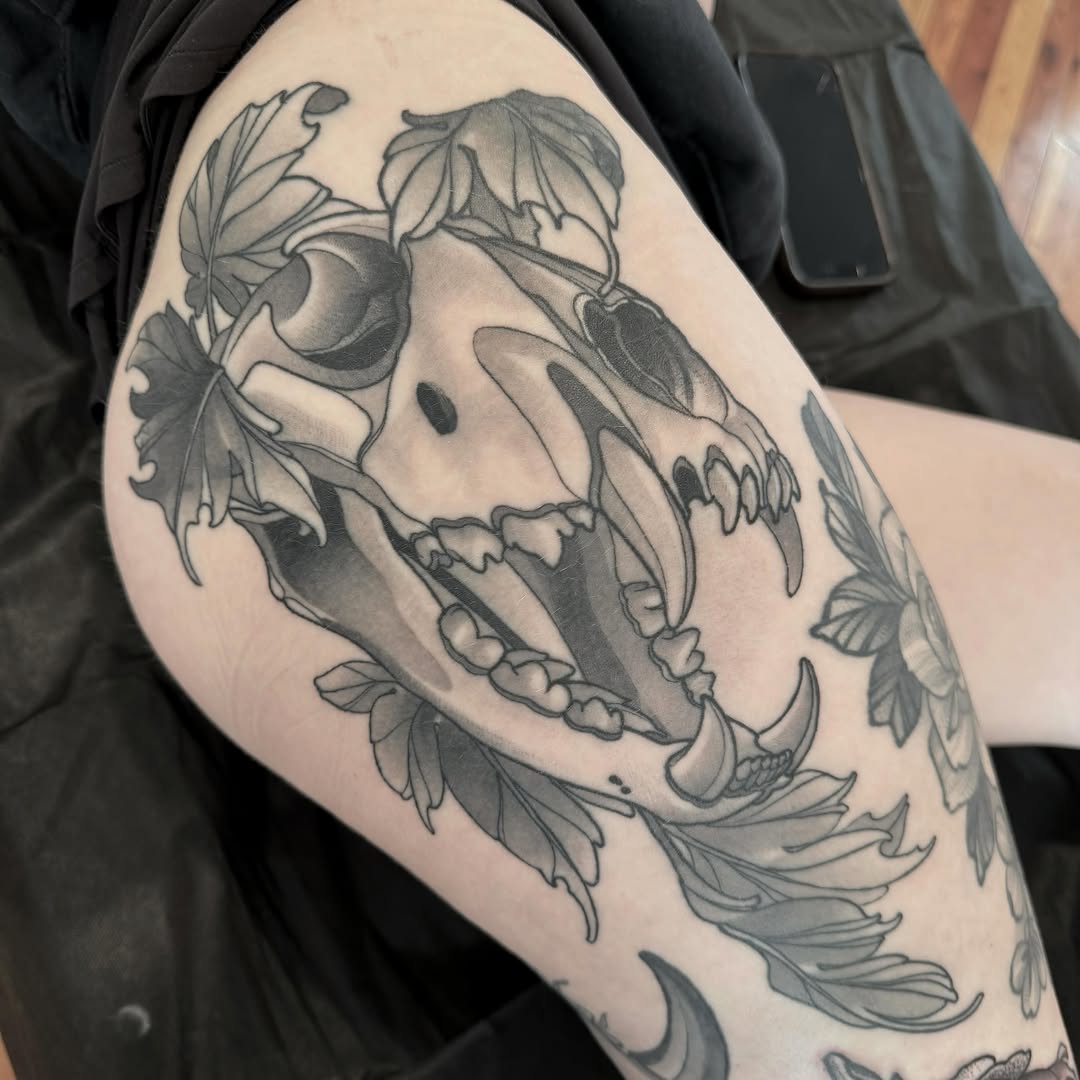 Wolf skull black and grey tattoo on the thigh by Anne Cornelson