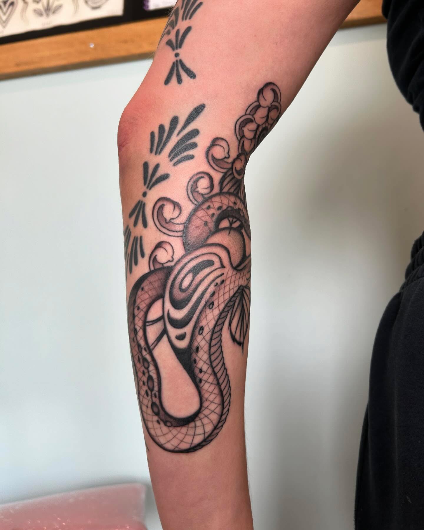 Snake black and grey tattoo on the forearm by Lilly Binns