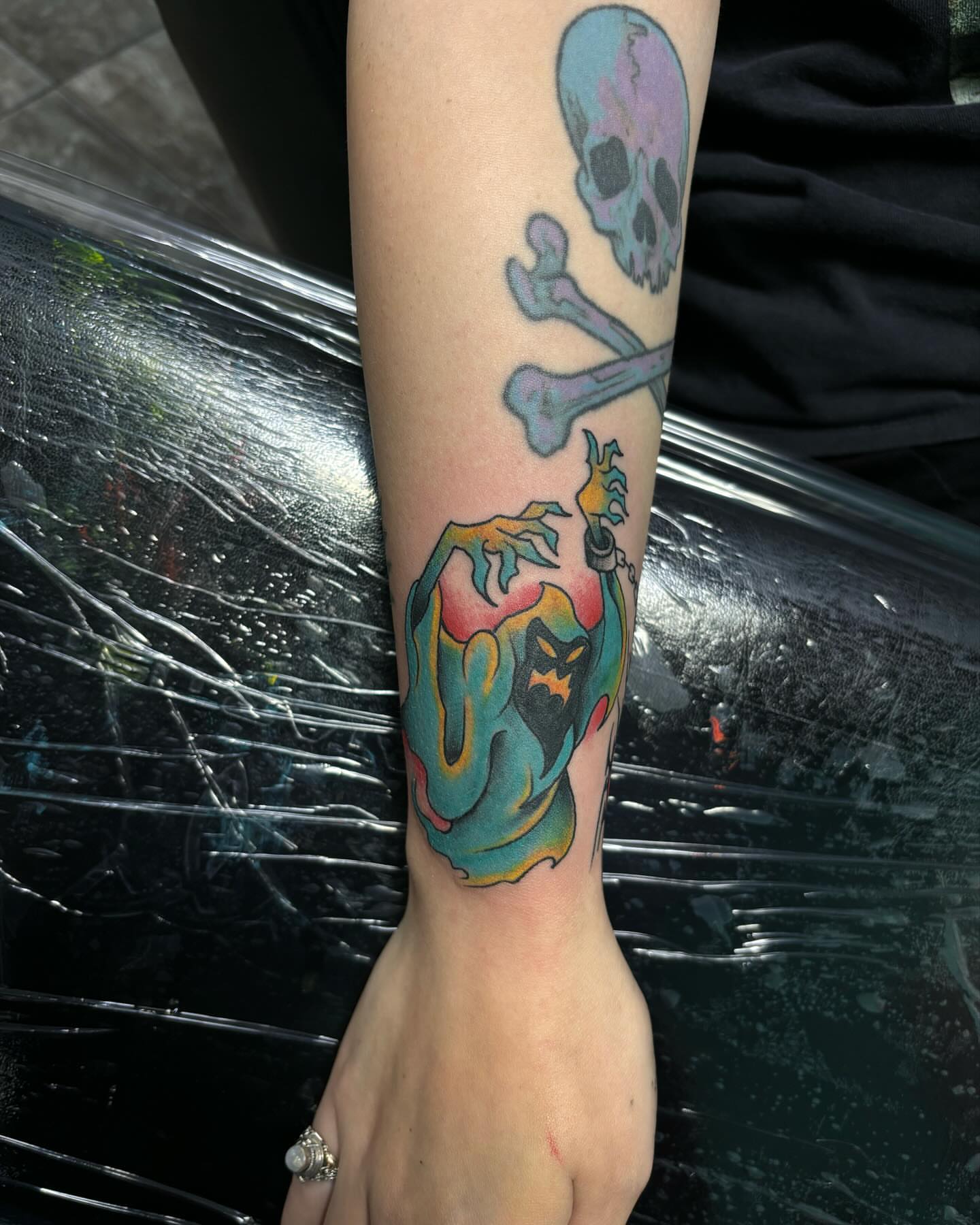 Skull and crossbones American traditional tattoo on the forearm by Ares Rhodes