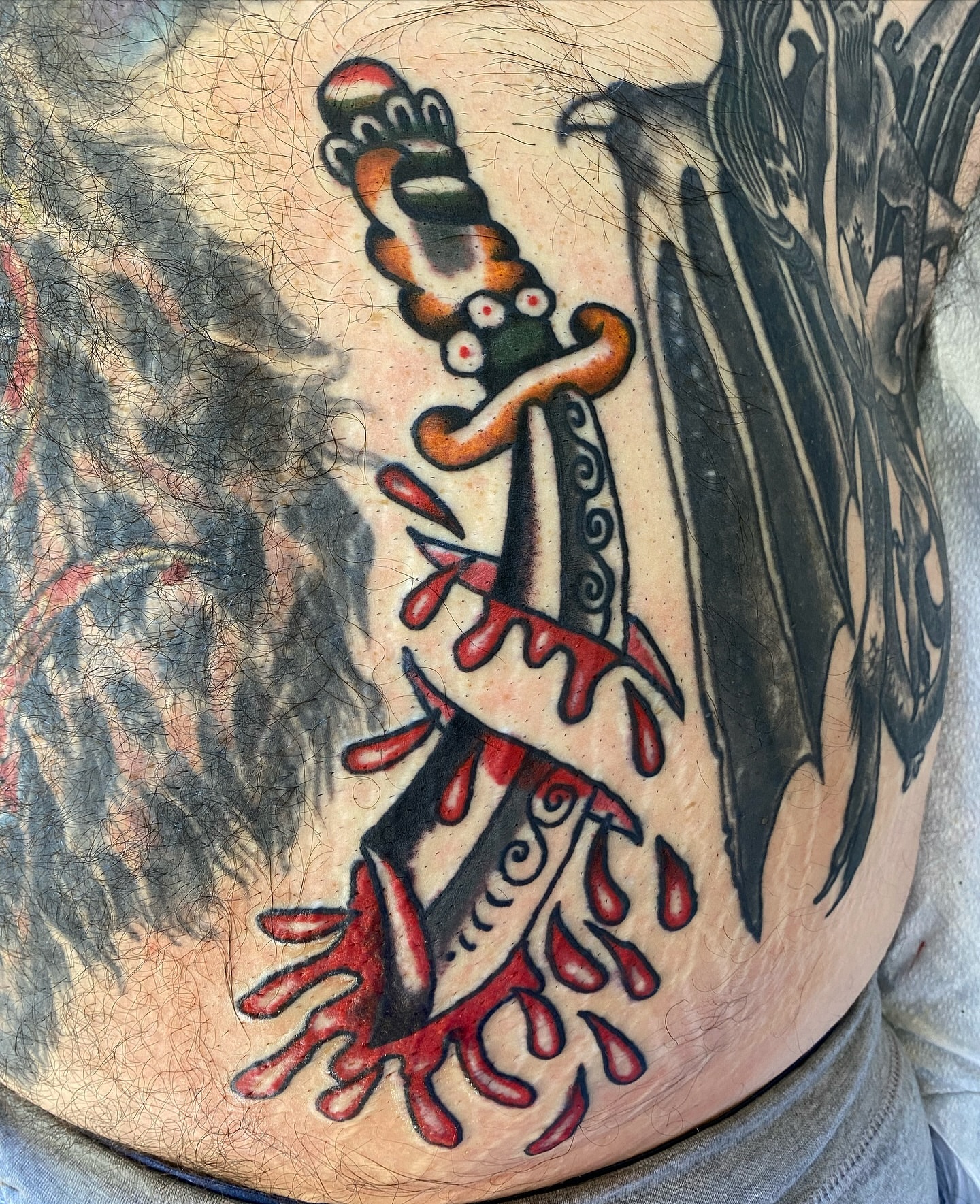 Sword with dripping blood American traditional tattoo on the torso by Joey Delarosa, San Francisco, California