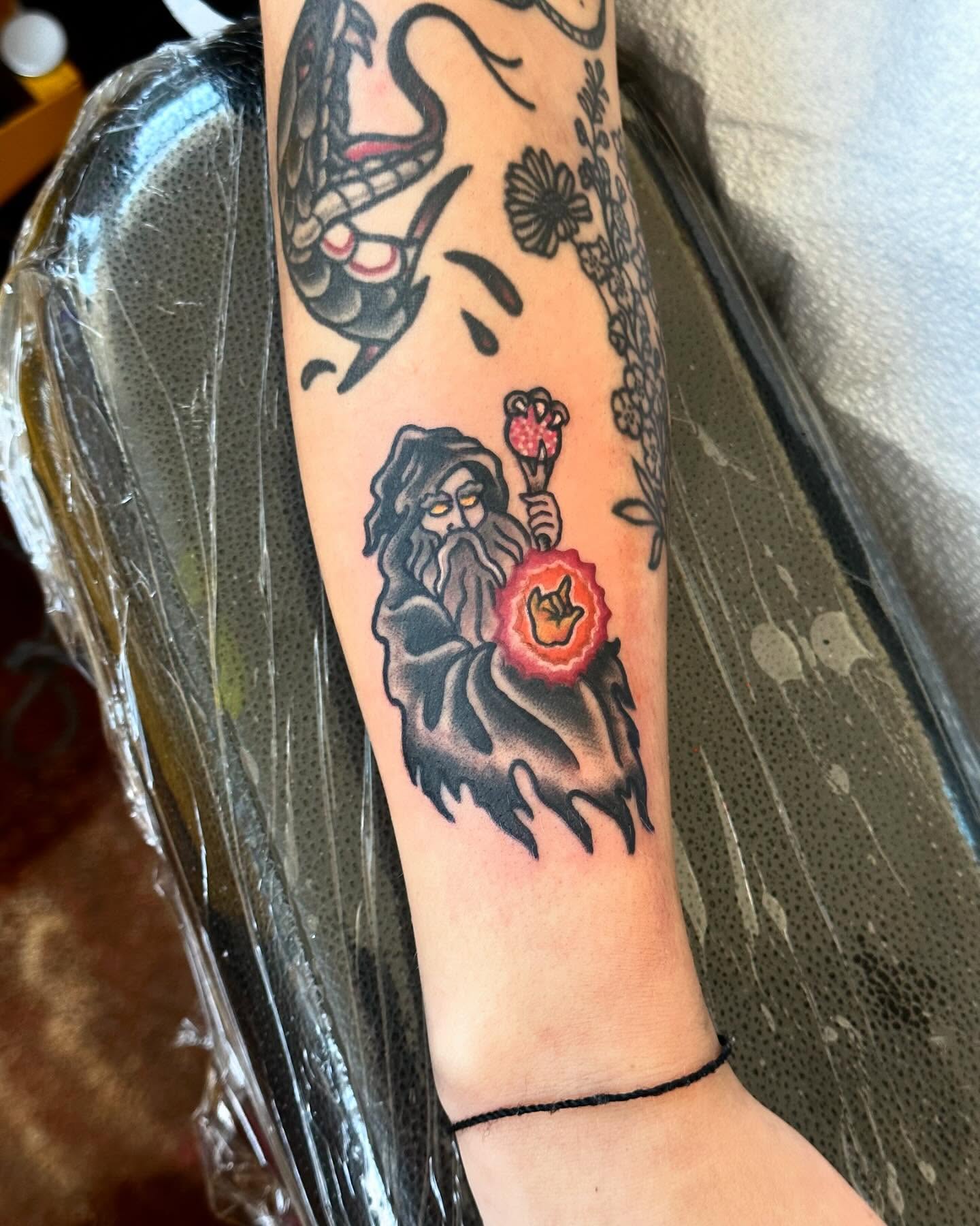 Wizard with flower American traditional tattoo on the forearm by Erin Miller