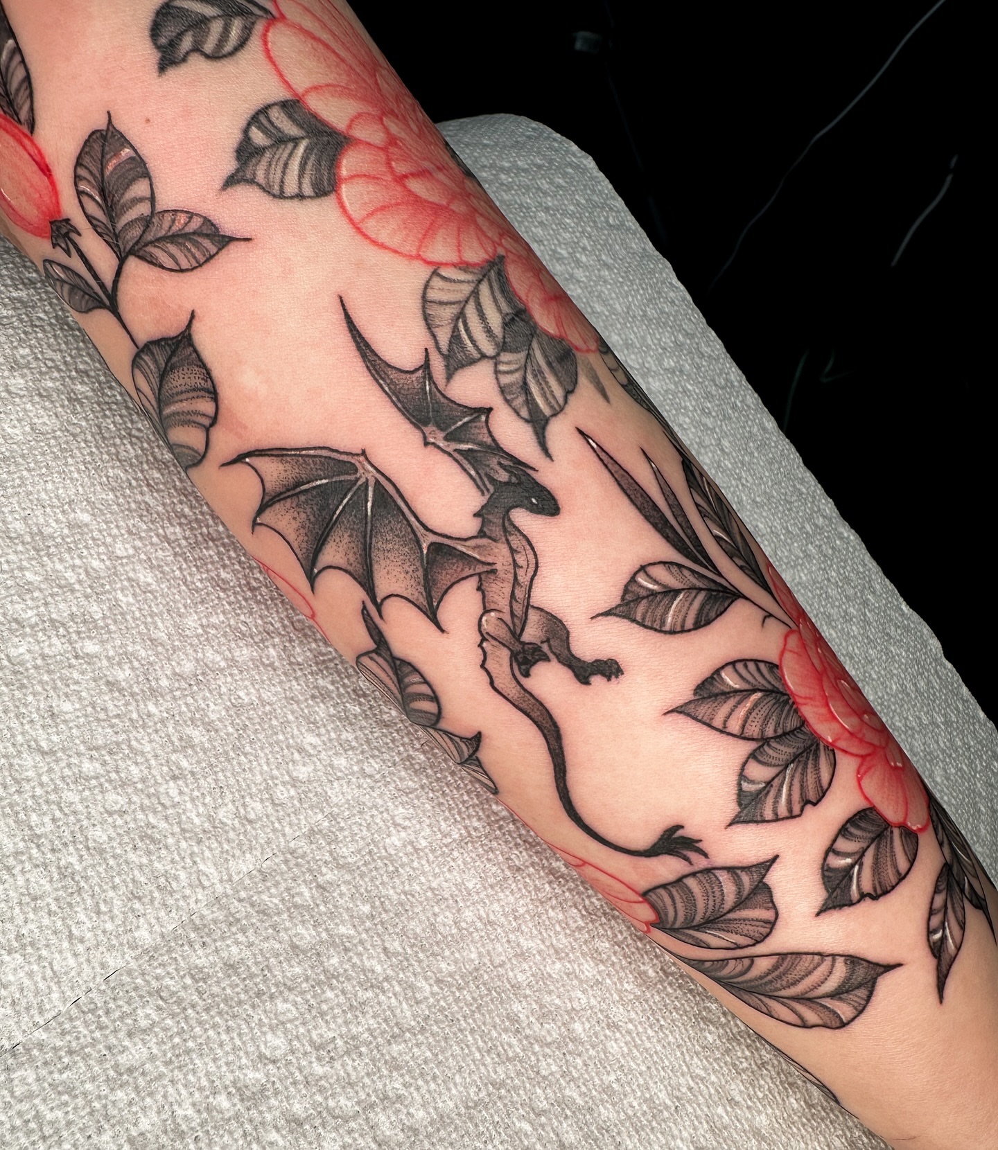 Bat and floral dotwork tattoo on the forearm by Tony Murray