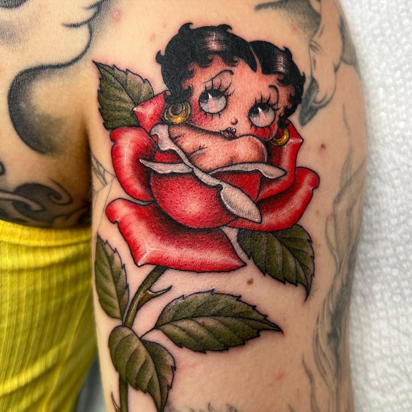 Betty Boop in a rose American traditional tattoo on the forearm by Valerie Dominguez