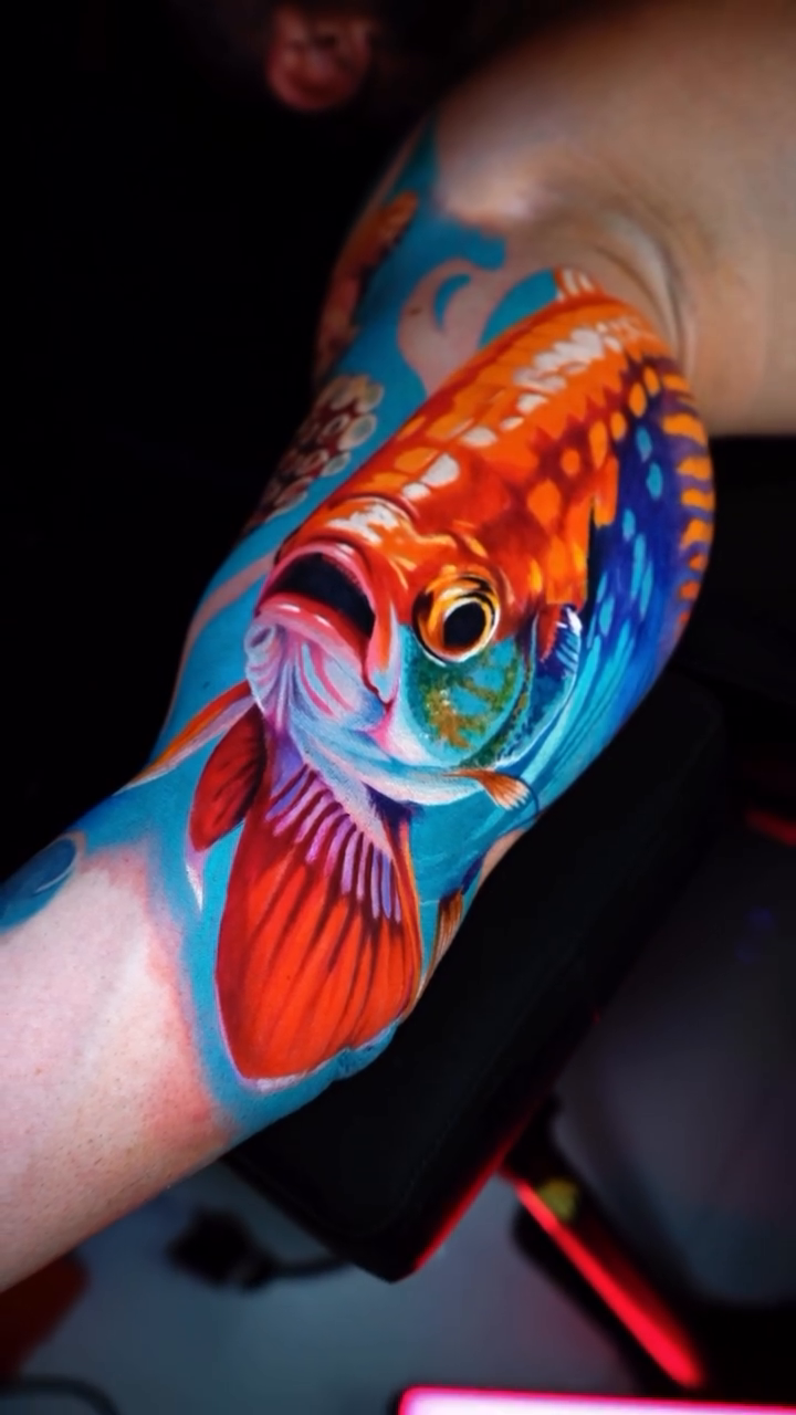Arowana fish tattoo surrealism tattoo on the upper arm by Andres García Baeza