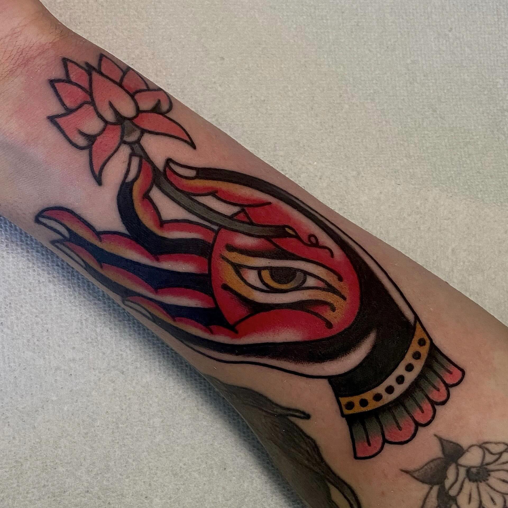 Flaming eye with lotus American traditional tattoo on the forearm by Erin Chambers