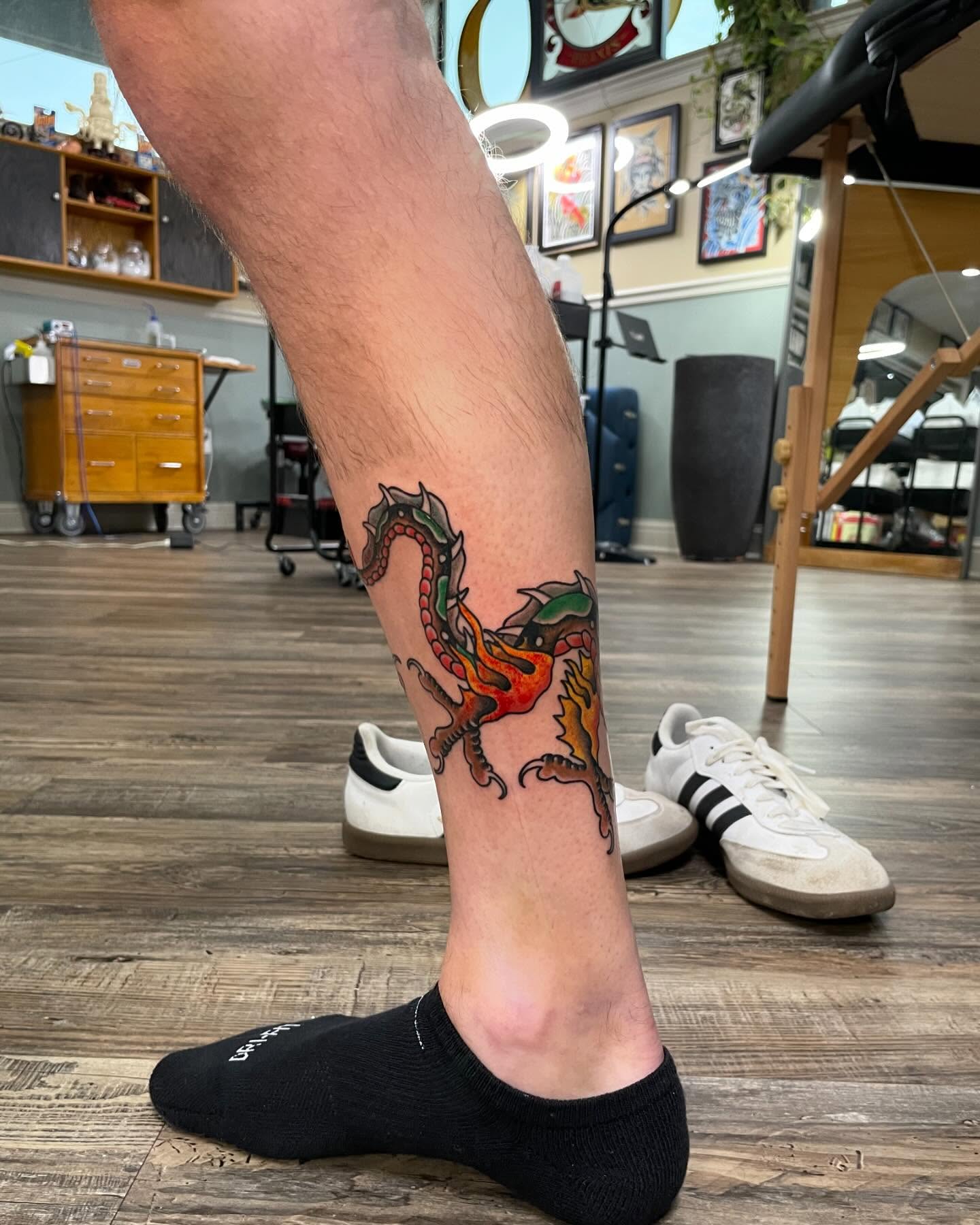 Dragon new school tattoo on the calf by Caleb Baker