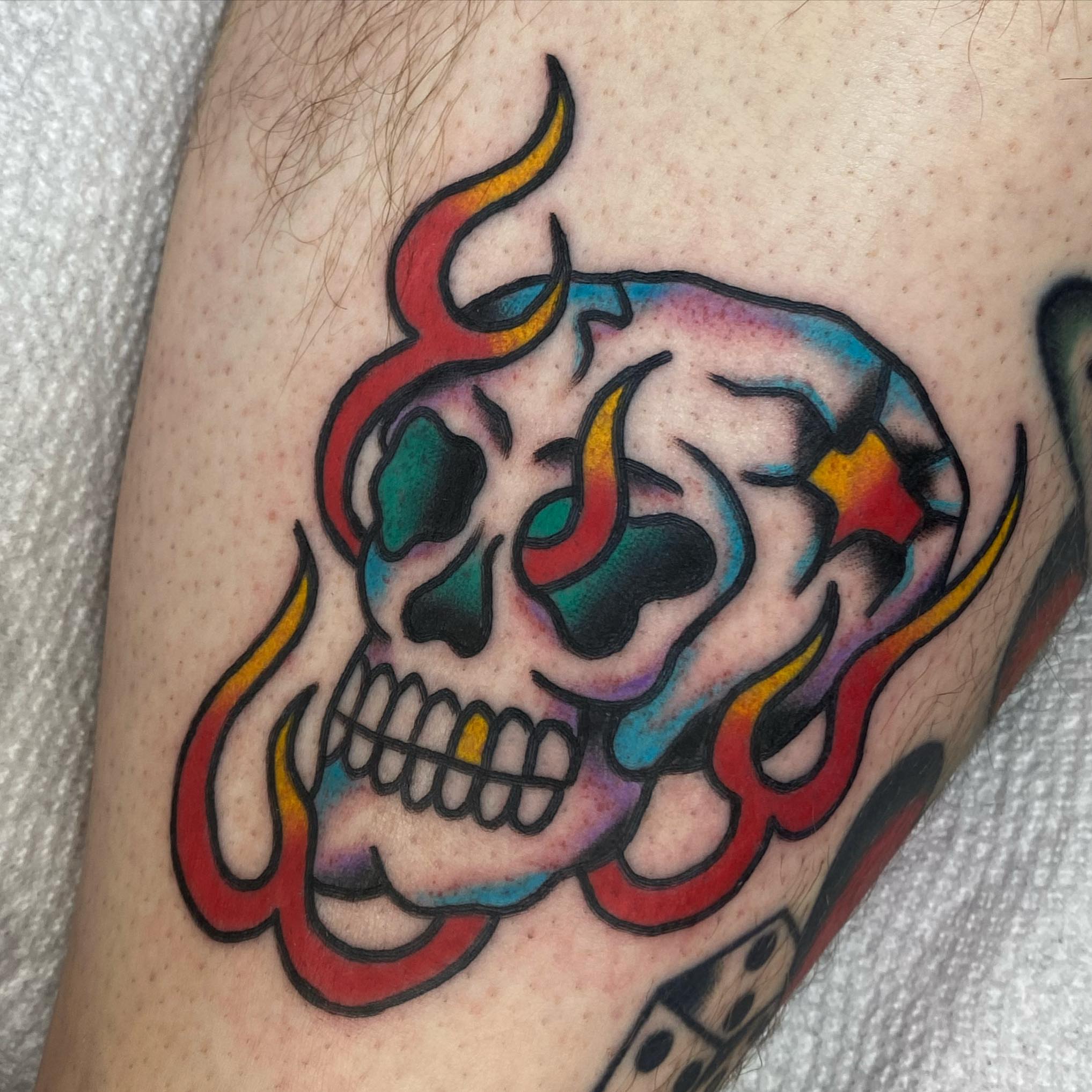 Skull with flames American traditional tattoo on the forearm by Shana