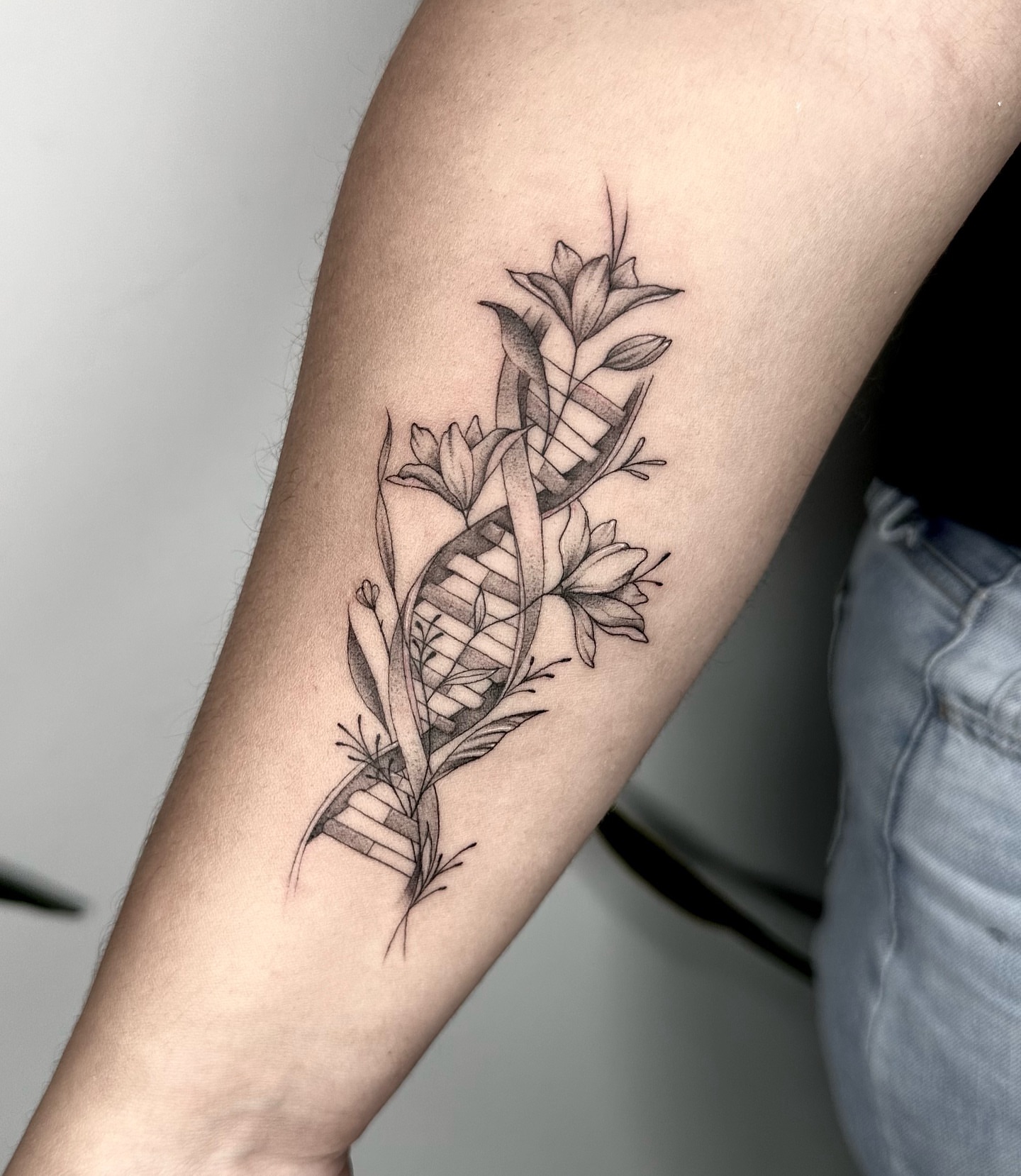 Floral arrangement black and grey tattoo on the forearm by Sophia Delfino