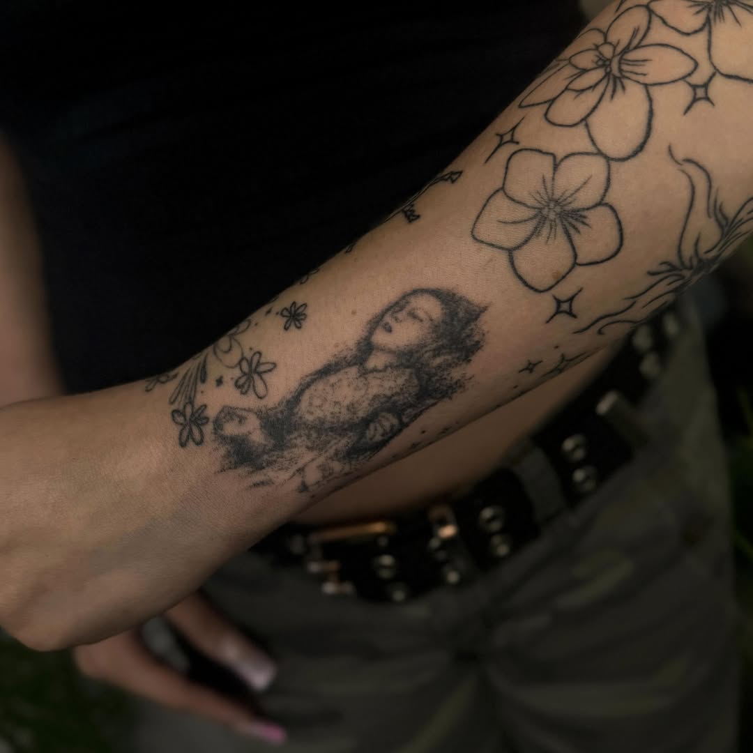Child and flowers black and grey tattoo on the forearm by Rose