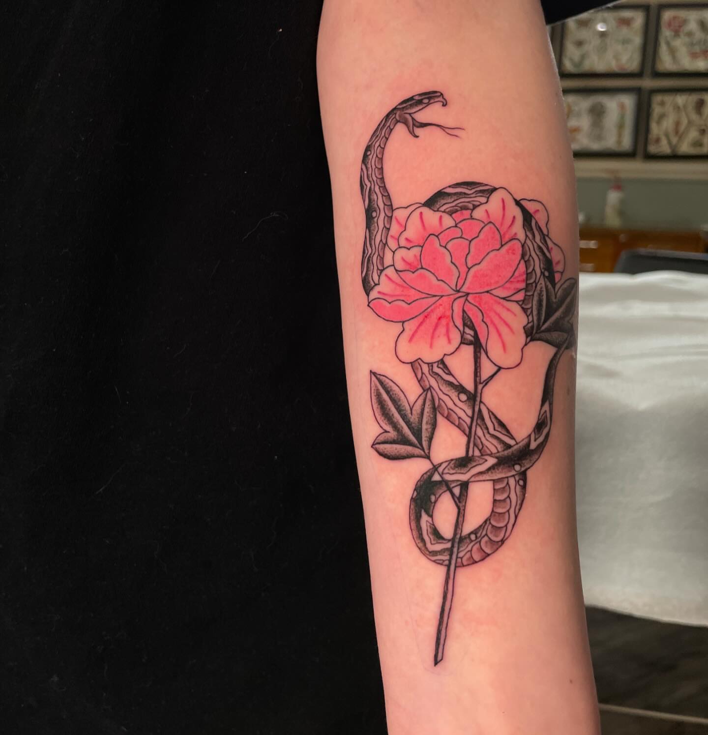 Snake and peony American traditional tattoo on the forearm by Caleb Baker