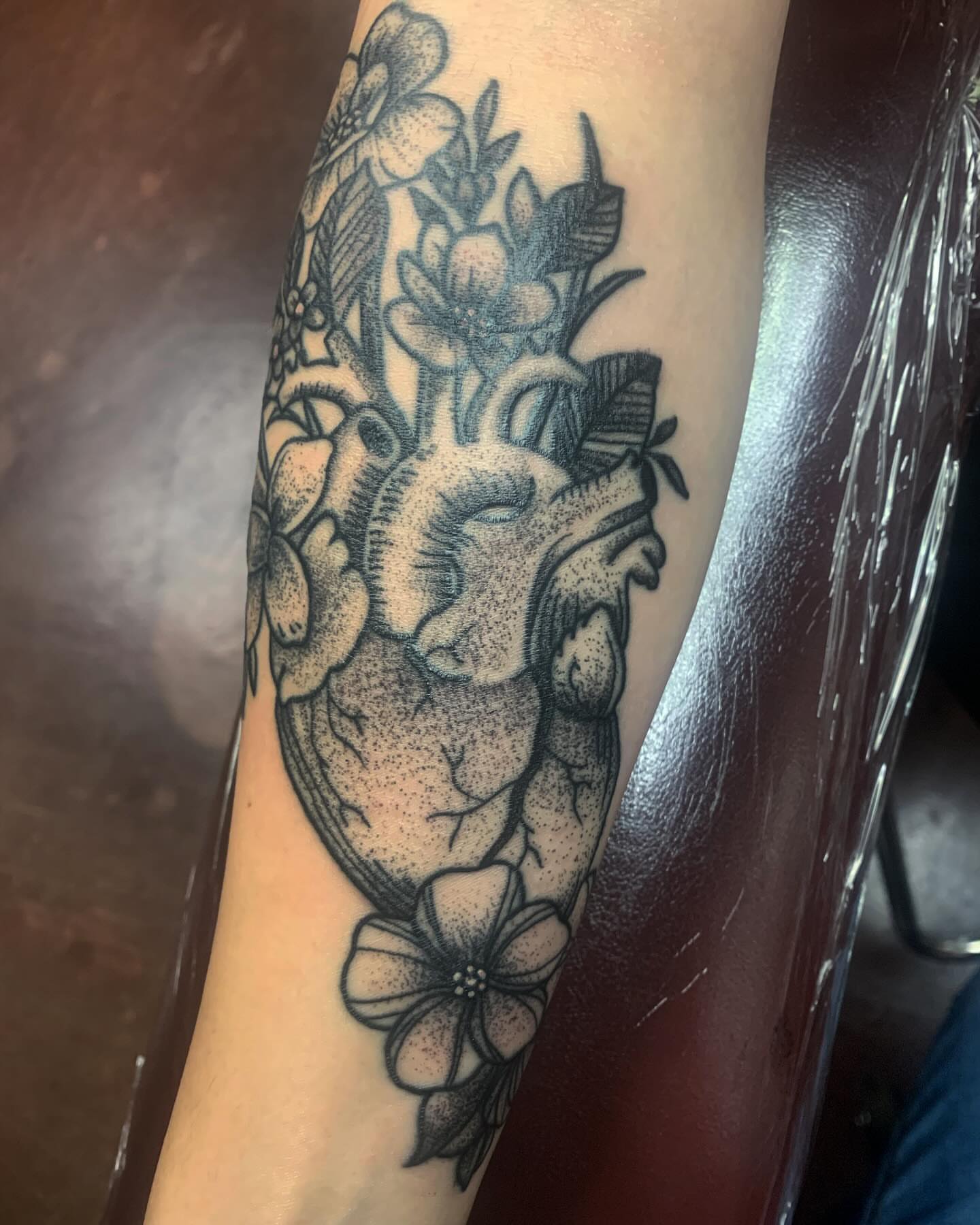 Heart with flowers dotwork tattoo on the forearm by Cody Marl