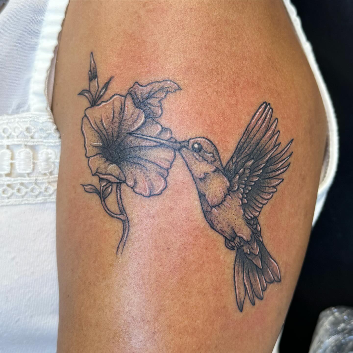 Hummingbird and flower realism tattoo on the thigh by Cory Perry-Servellon