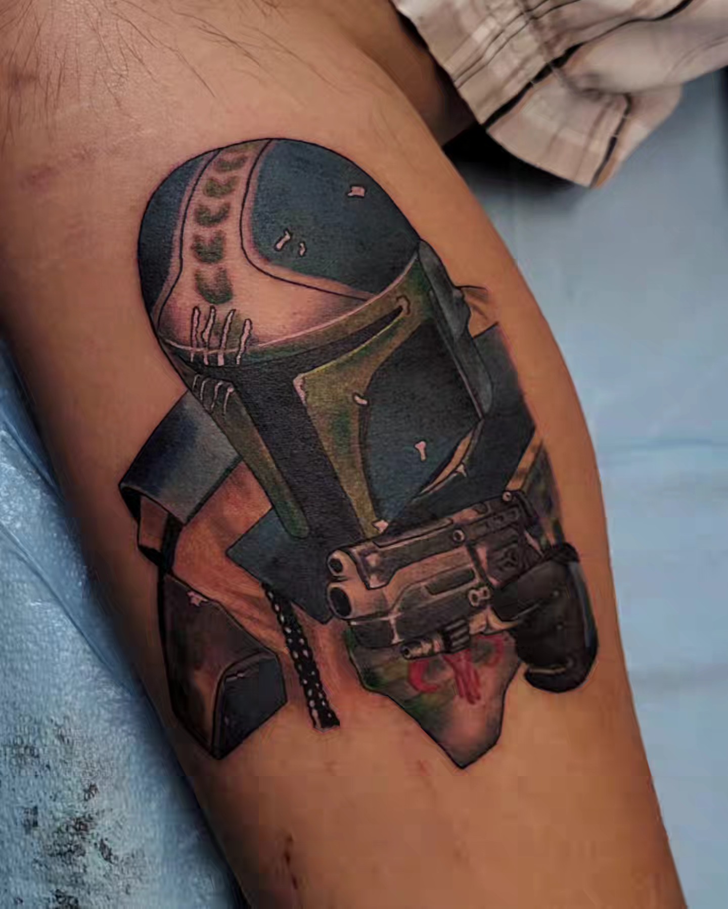 Mandalorian helmet realism tattoo on the upper arm by Marina Cobb