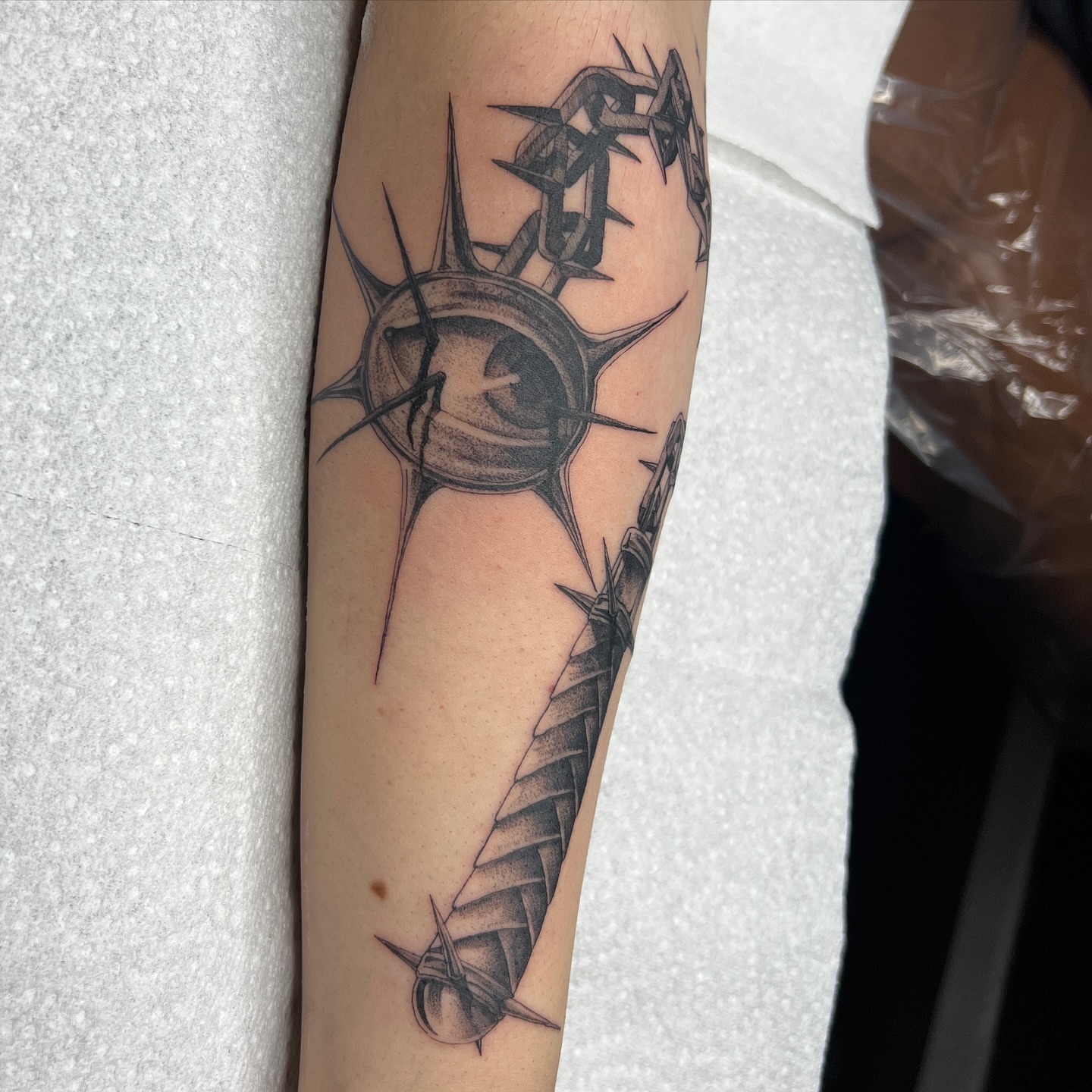 Sword and crown geometric tattoo on the forearm by Neeko