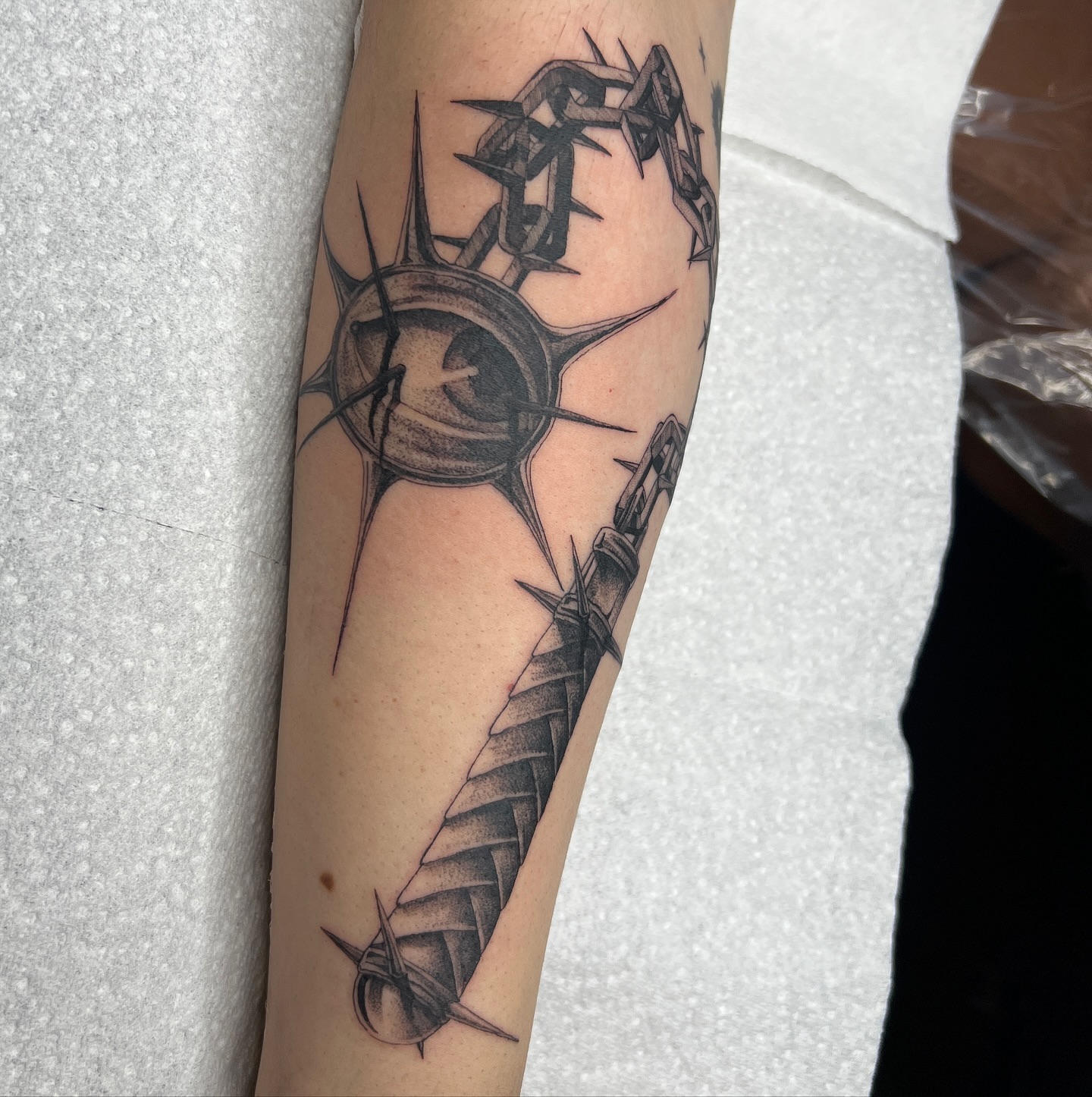 Crown of thorns and sword geometric tattoo on the forearm by Neeko