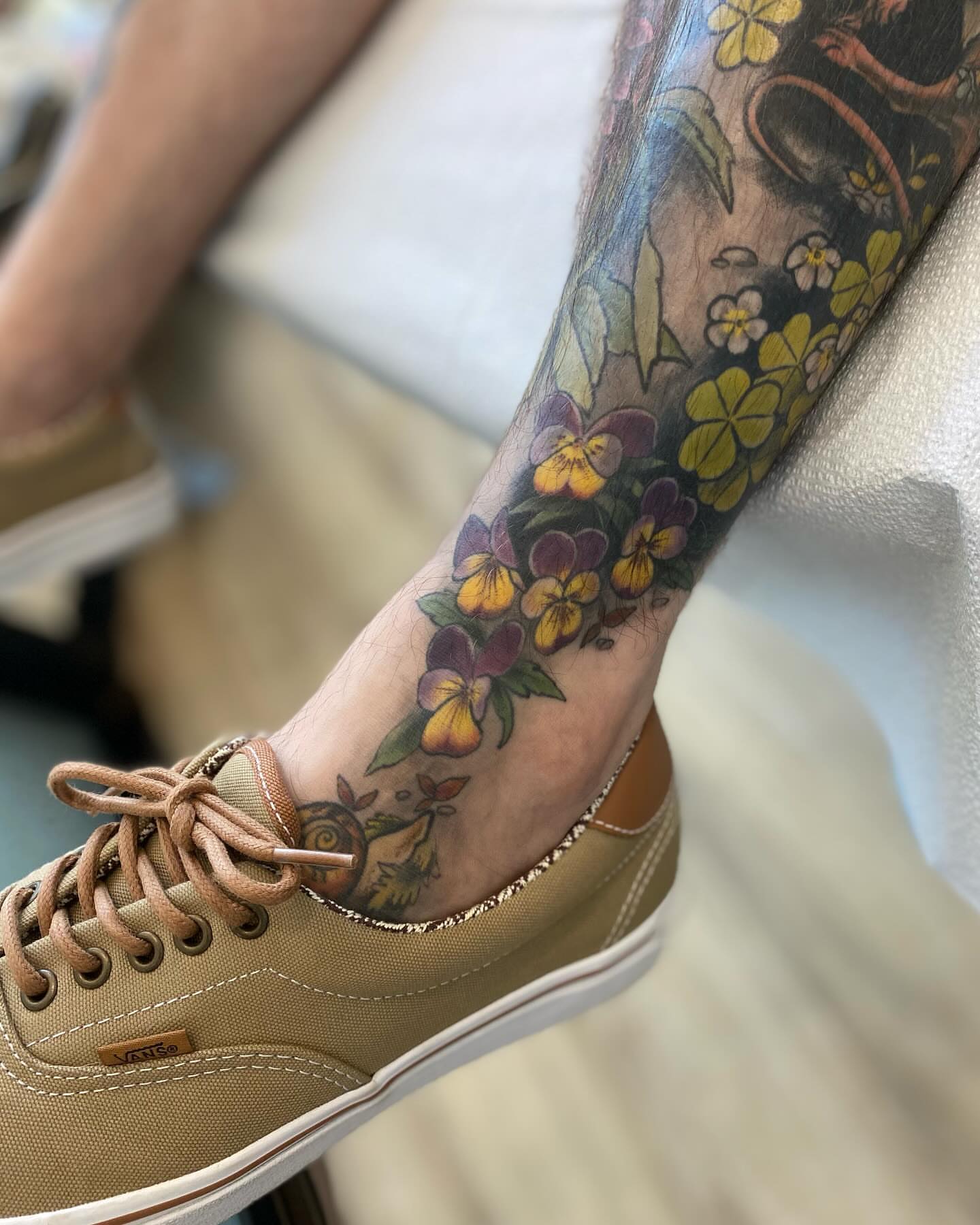 Violet flowers new school tattoo on the forearm by Rusty Indigo
