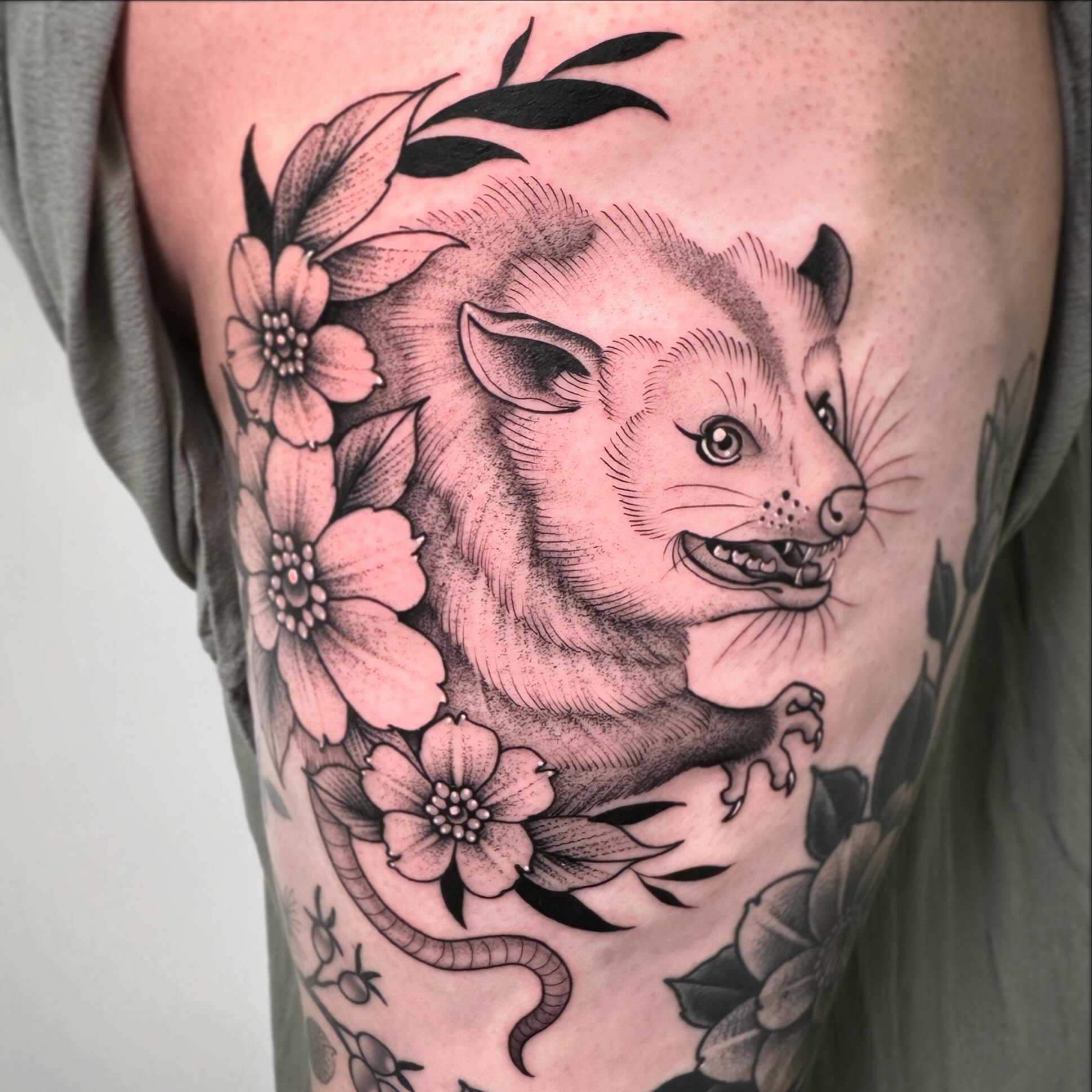 Possum and flowers American traditional tattoo on the upper arm by Patrick Whiting
