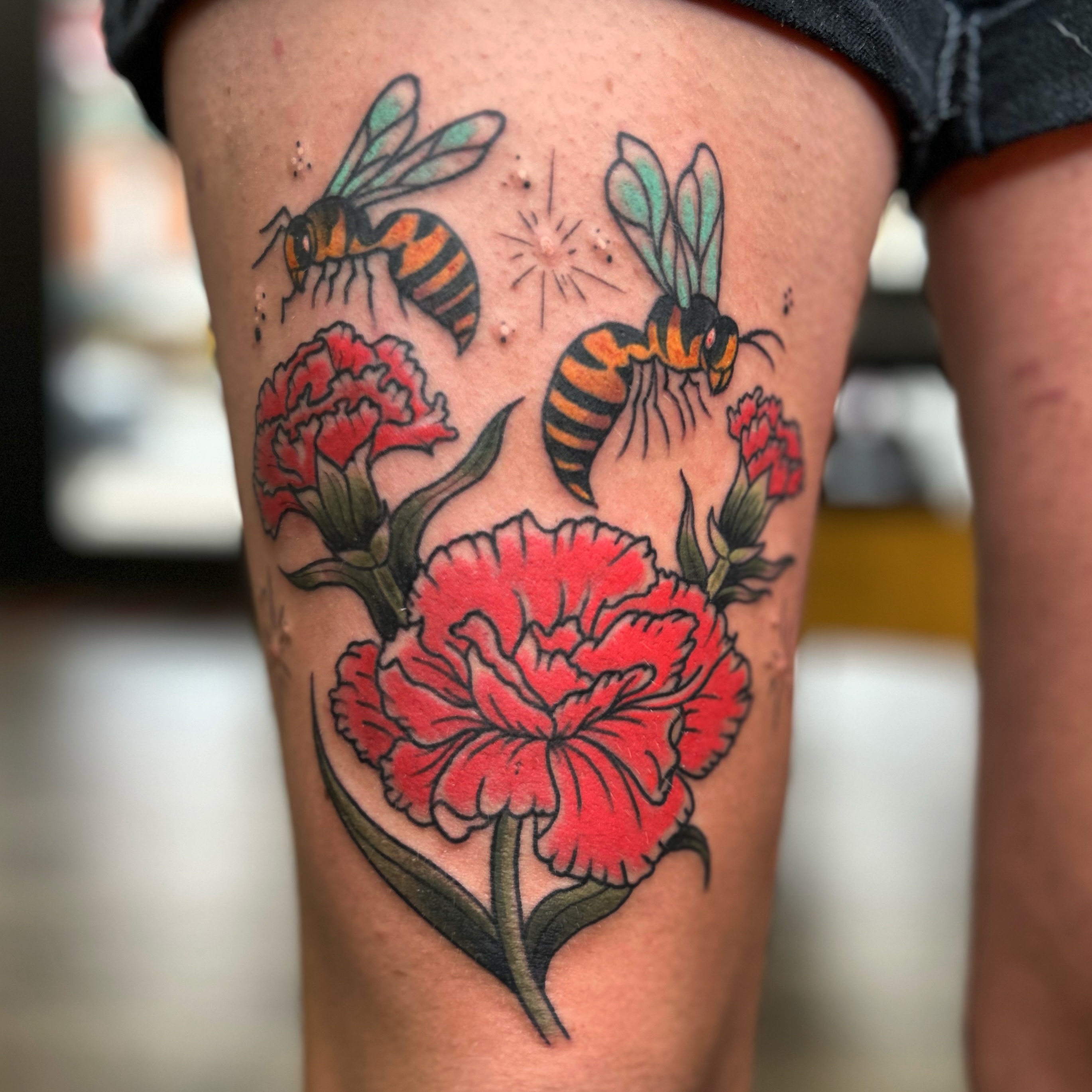 Bees and carnations American traditional tattoo on the thigh by Alex Fannin