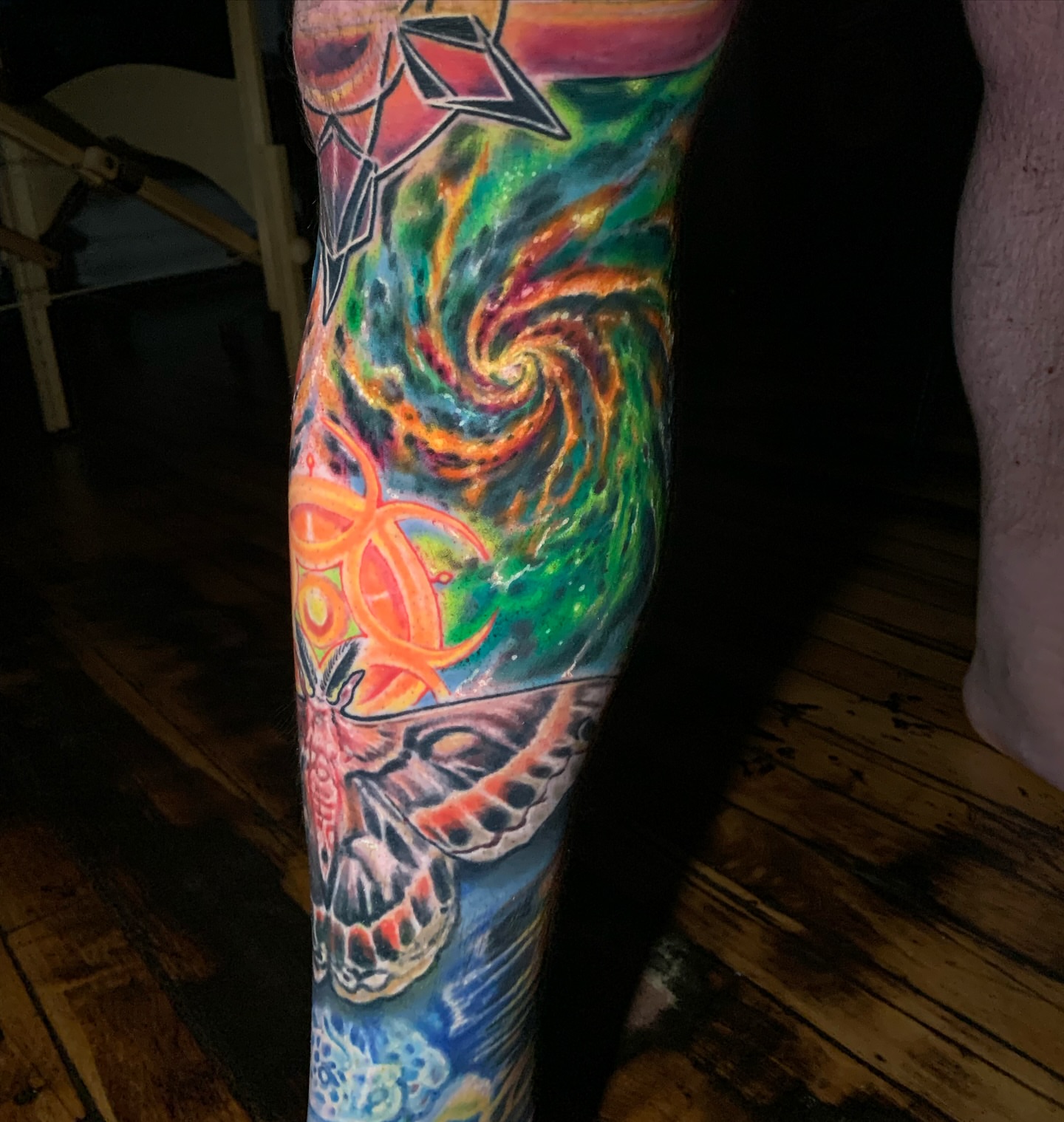 Galactic swirl with skull surrealism tattoo on the leg by Phil Robertson