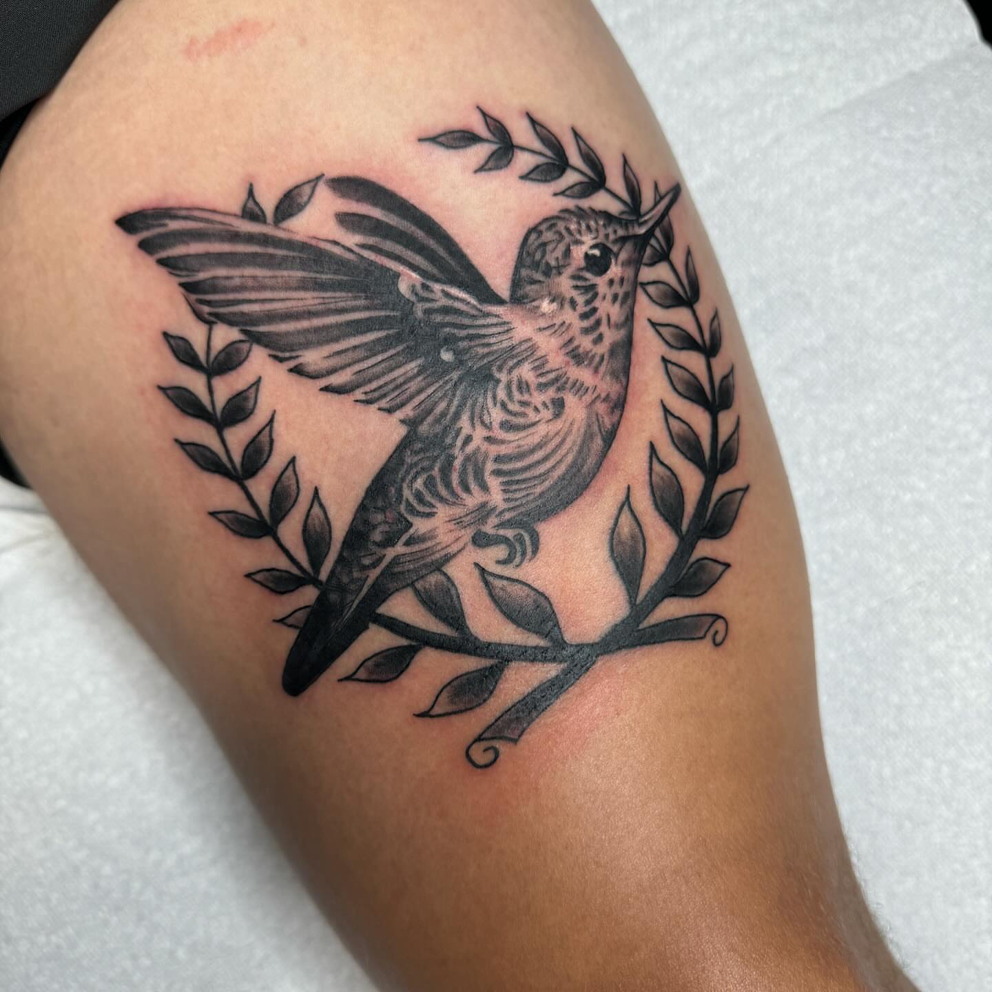 Hummingbird black and grey tattoo on the thigh by Anthony Pichardo 🦇