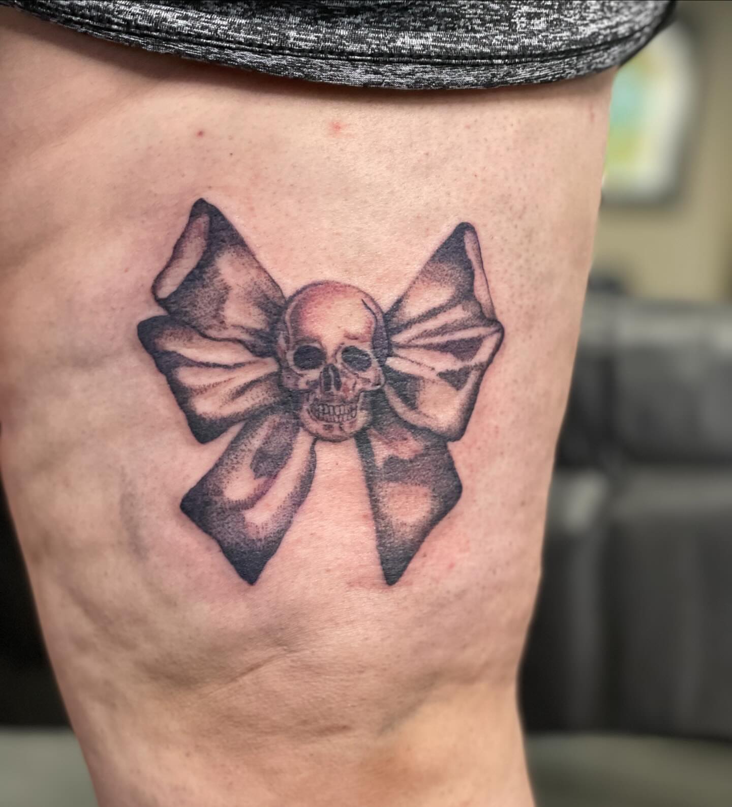 Skull with bow black and grey tattoo on the thigh by ⊹ * . 𝕵az ⊹ * .