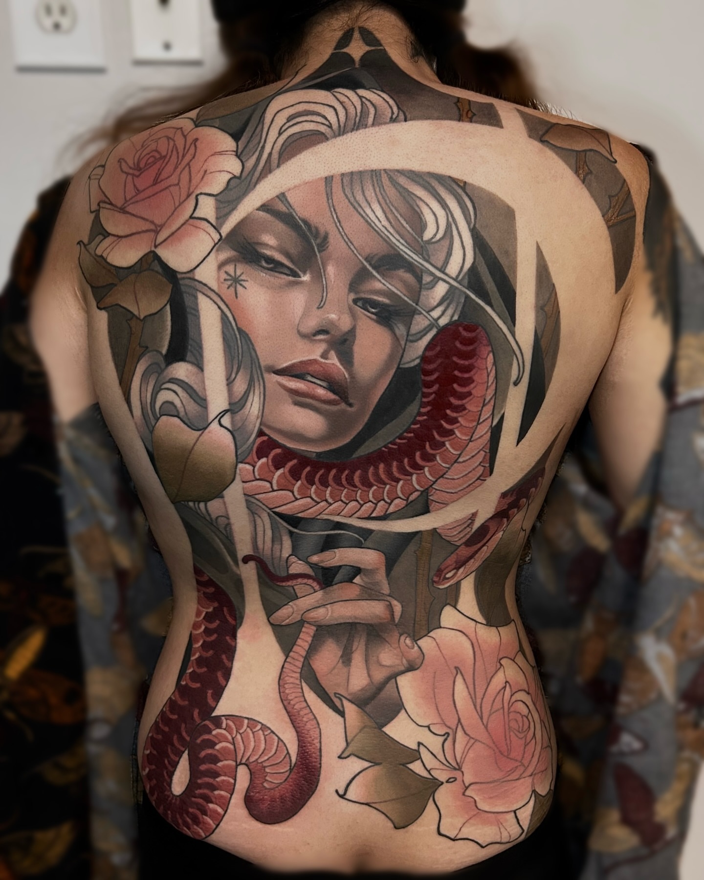 Woman with snake American traditional tattoo on the back by Levi Murphy