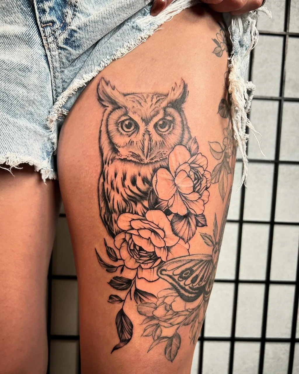 Owl and flowers realism tattoo on the thigh by Dylan Stevens