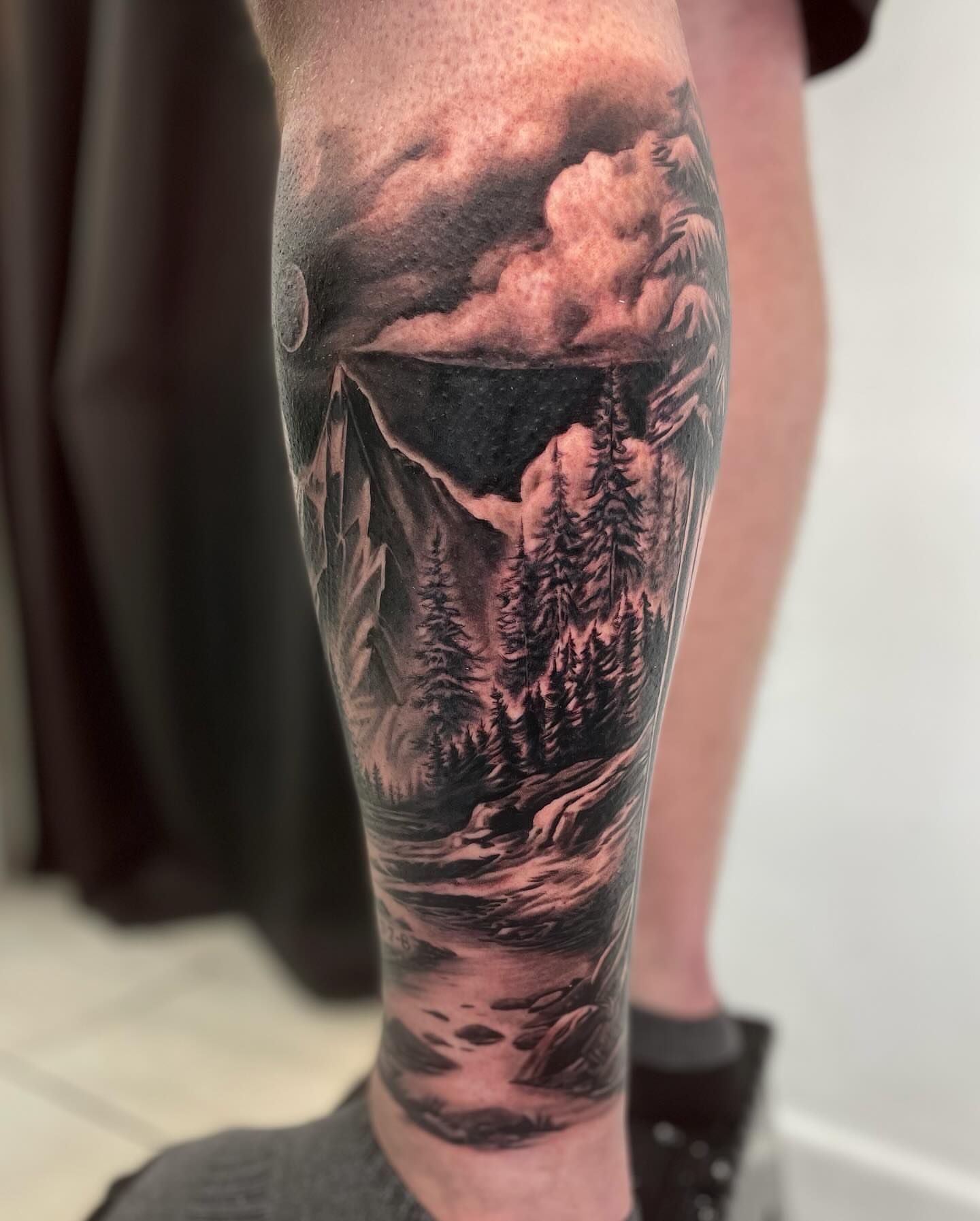 Mountain landscape realism tattoo on the calf by Justin Reid, San Jose, California