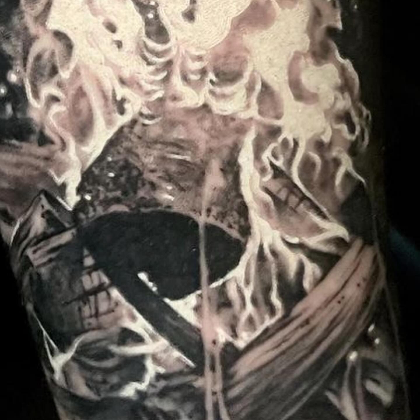 Flaming bird black and grey tattoo on the upper arm by Gabe Jensen