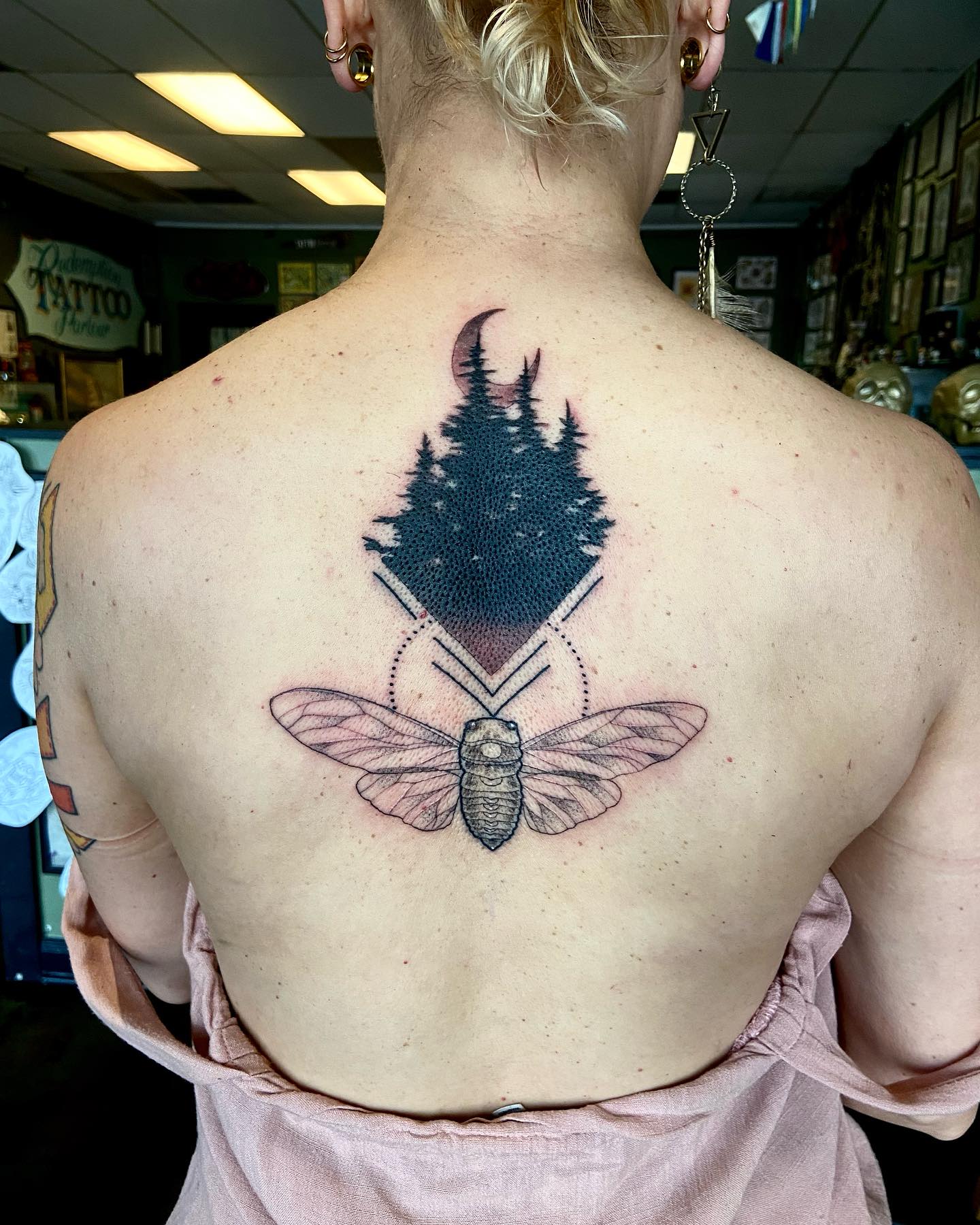 Cicada and forest scene fine line tattoo on the back by Dorrough Tattooer