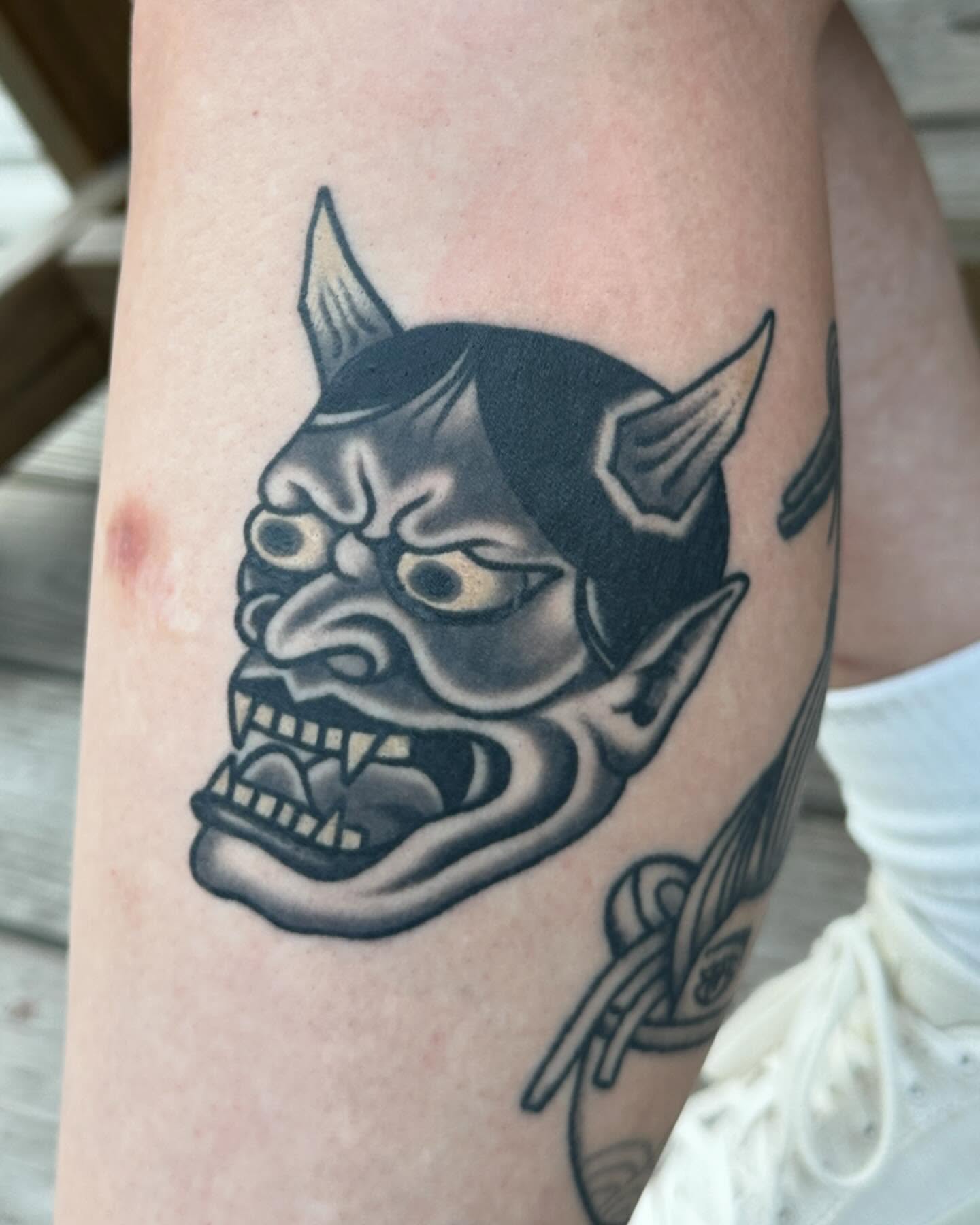 Demon mask black and grey tattoo on the forearm by Chaz Otto