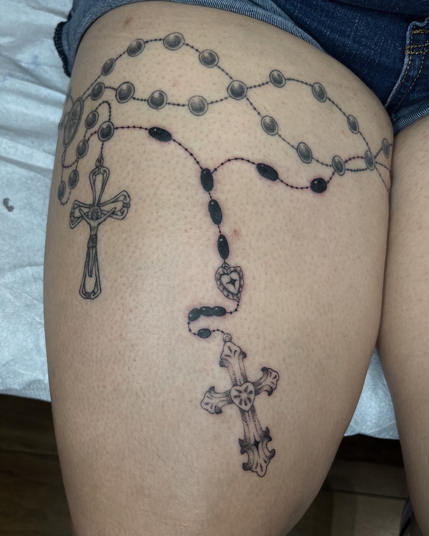 Rosary black and grey tattoo on the thigh by Taylor Newton