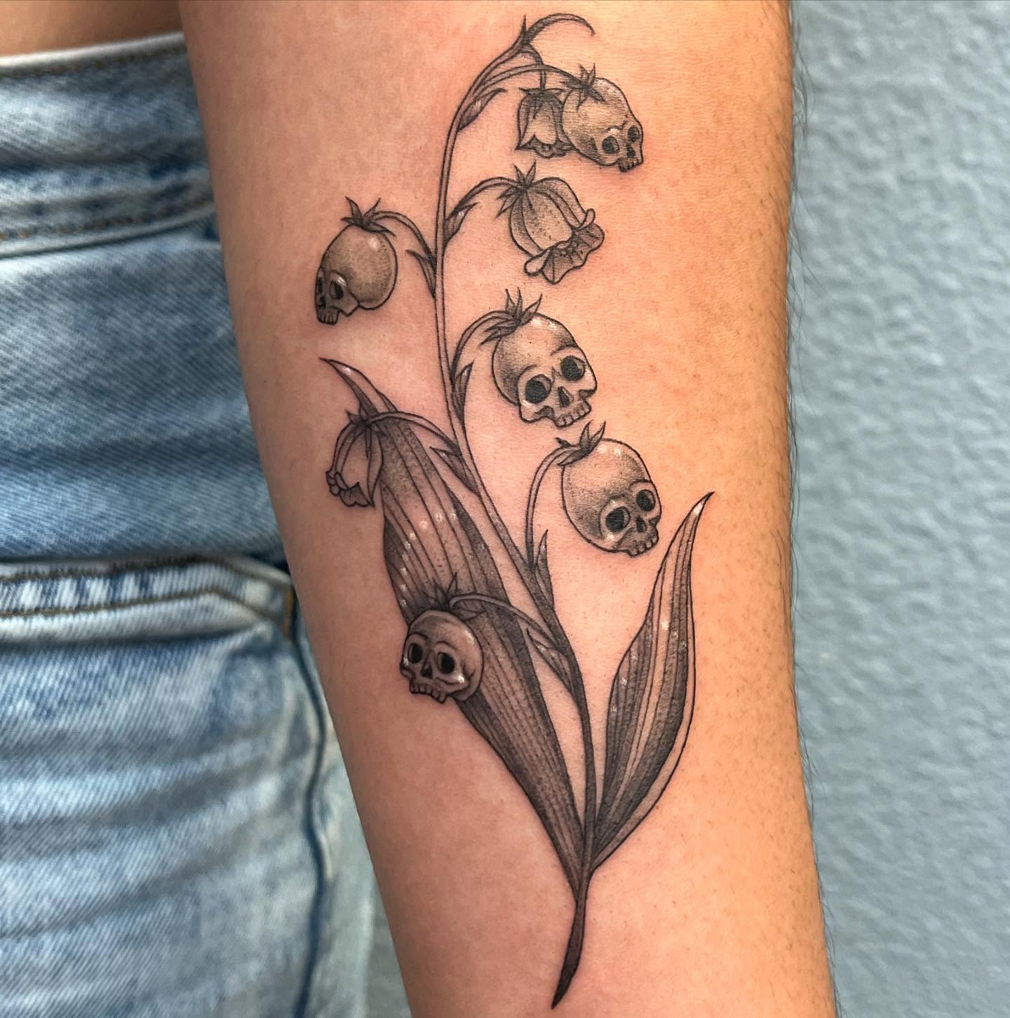 Lily of the valley skulls black and grey tattoo on the forearm by Ana Valadez π¦, Ventura, California