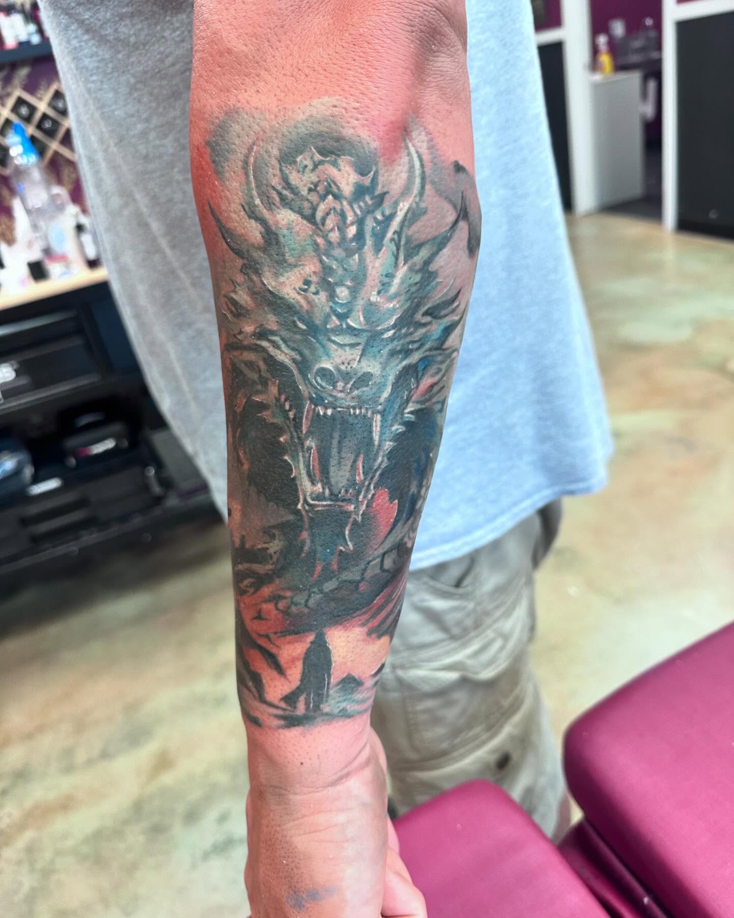 Dragon dark realism tattoo on the forearm by Shawn Cook
