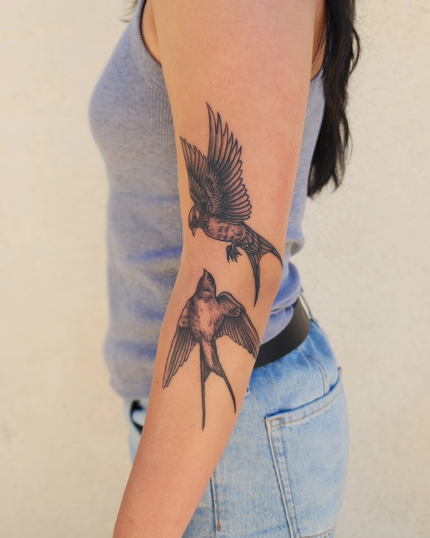 Swallows black and grey tattoo on the forearm by Bry True