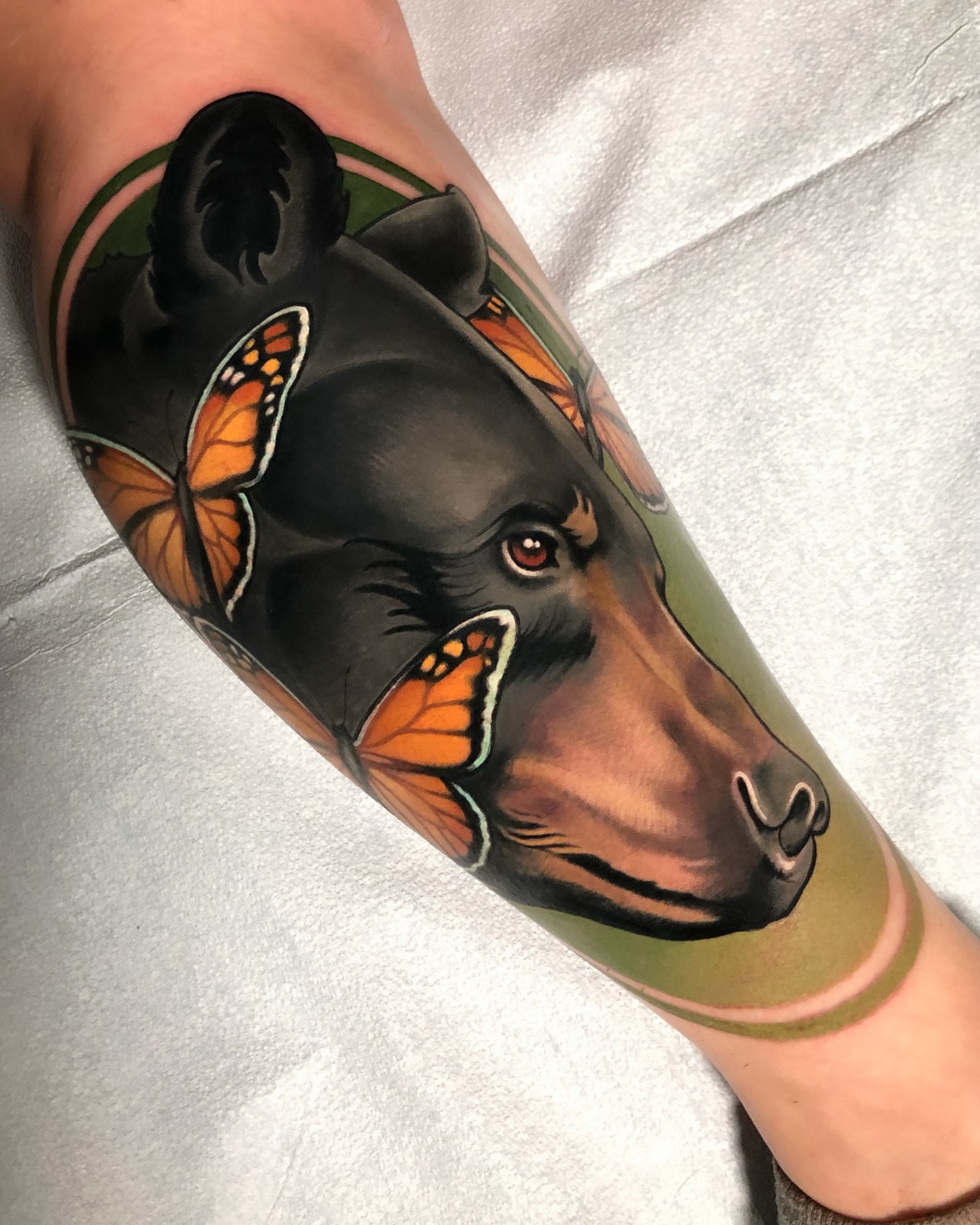 Bear and butterflies realism tattoo on the forearm by Milo Alfring Tattoo