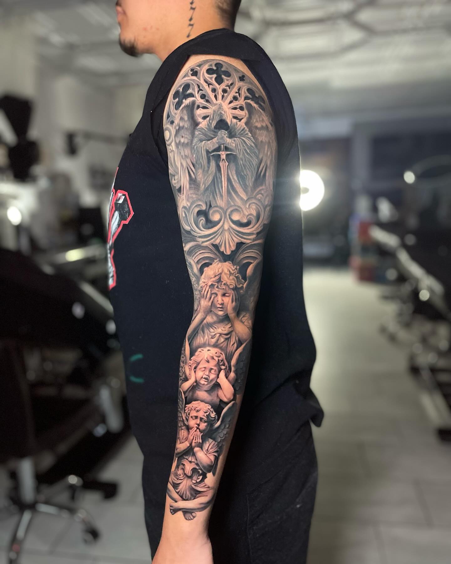 Religious icon with cherubs realism tattoo on the forearm by Justin Reid, San Jose, California