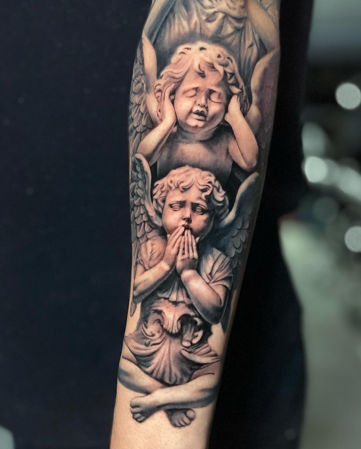 Cherubs black and grey tattoo on the forearm by Justin Reid, San Jose, California