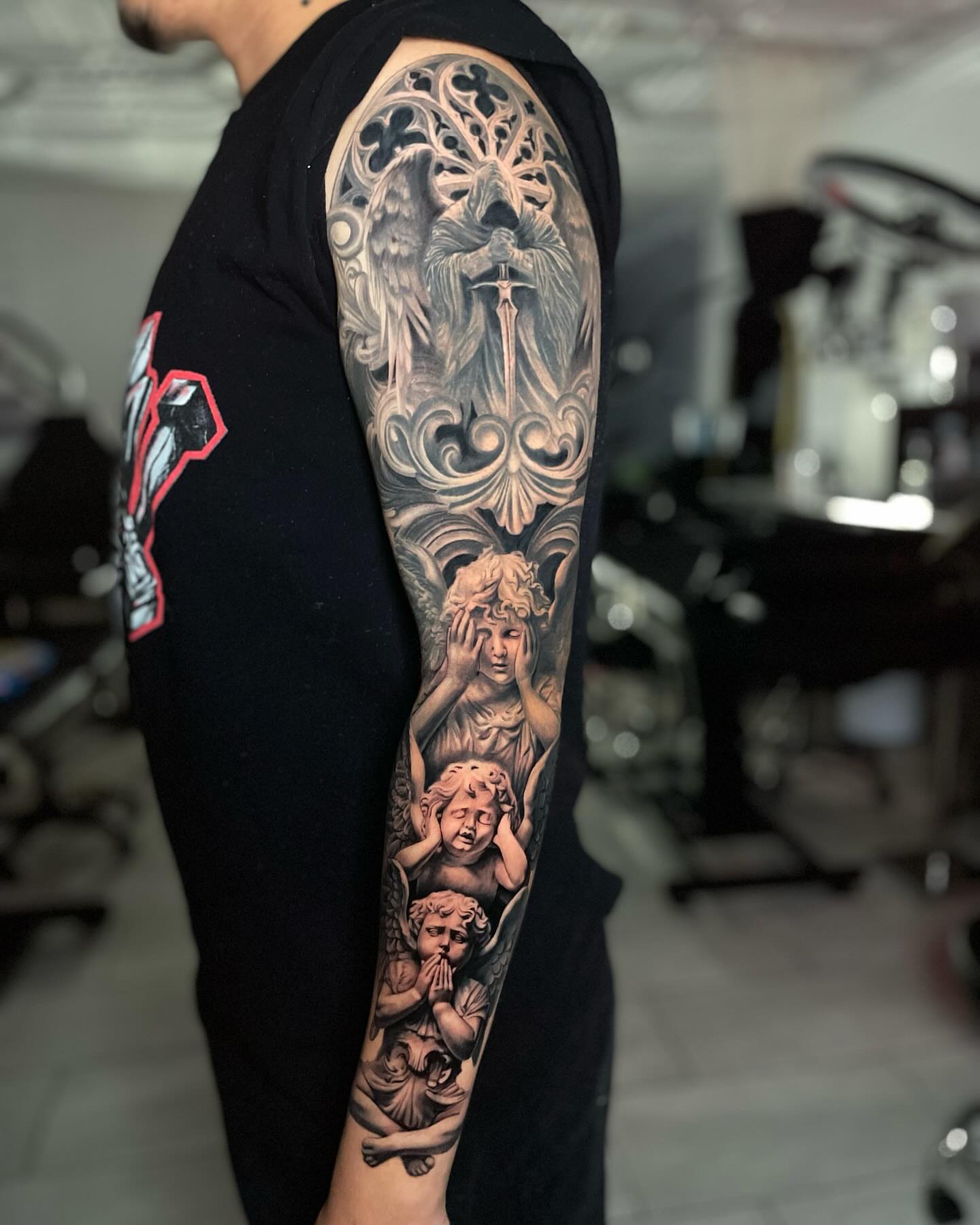 Angels and cherubs realism tattoo on the forearm by Justin Reid, San Jose, California
