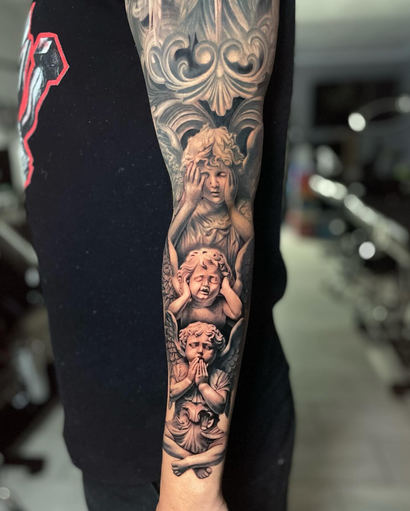 Cherubs praying realism tattoo on the forearm by Justin Reid, San Jose, California