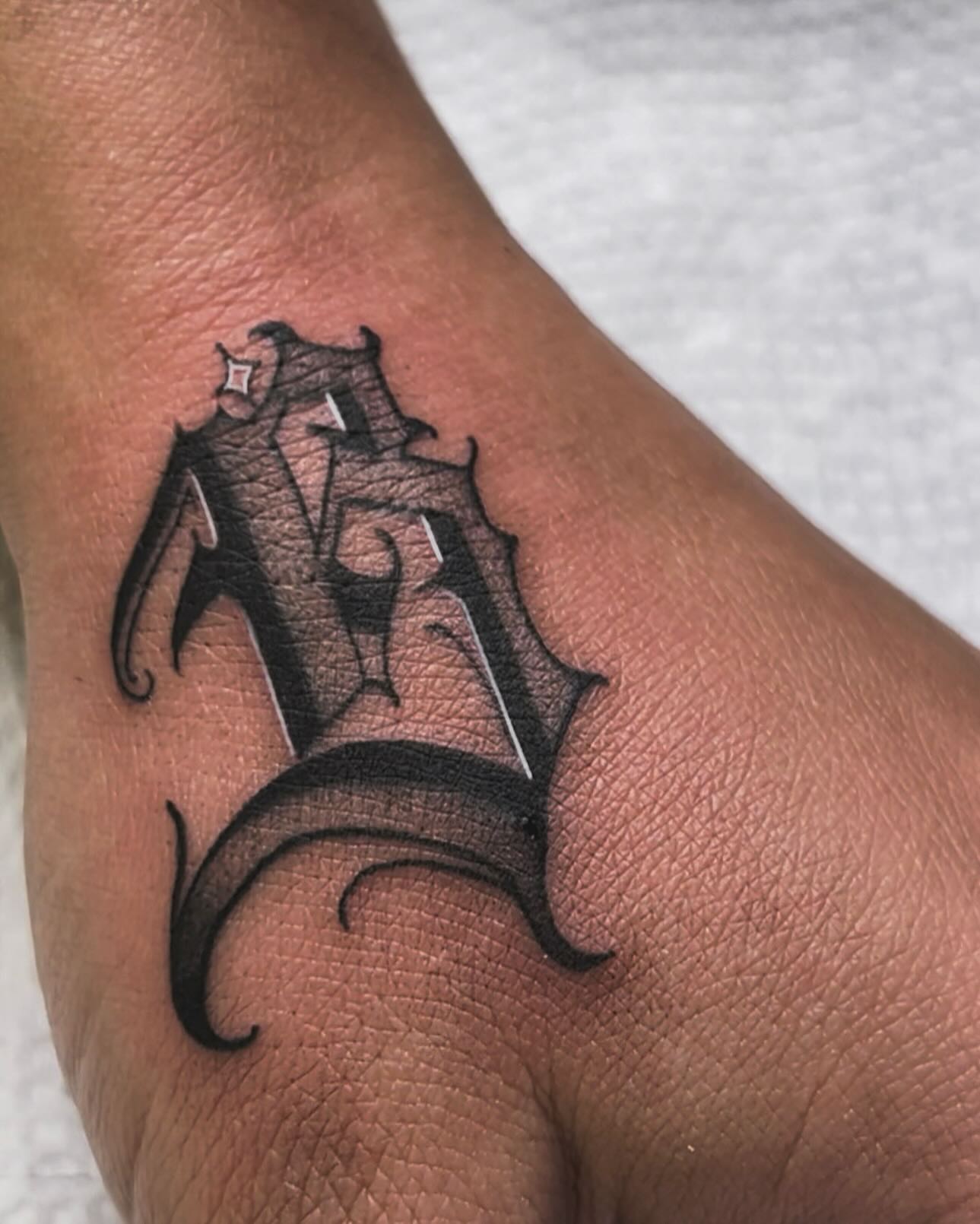 Lettering black and grey tattoo on the forearm by Tattoo Artist
