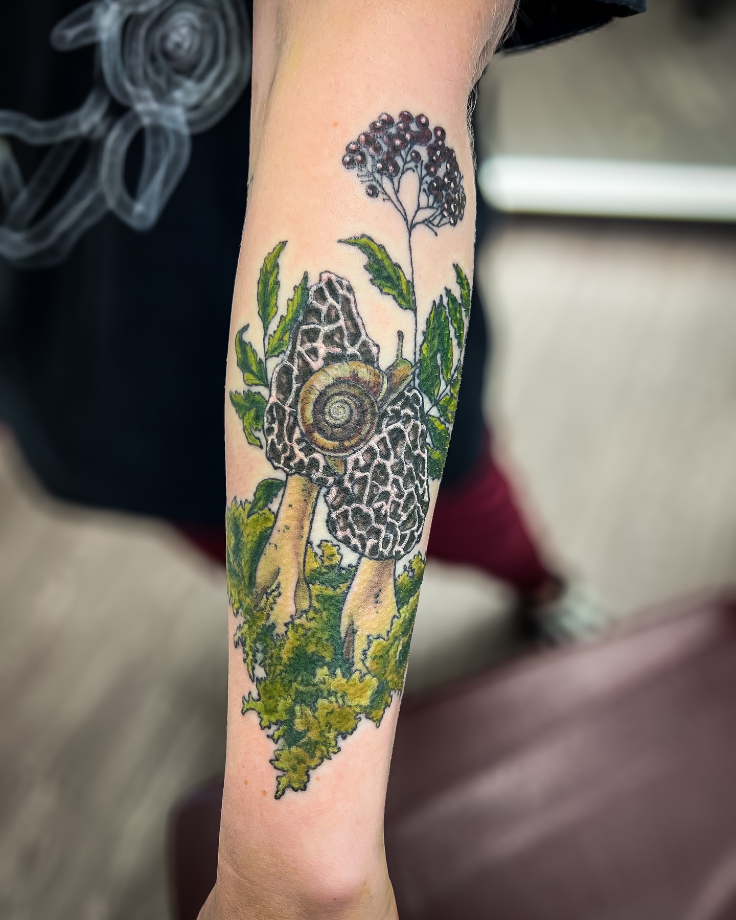 Snail and foliage realism tattoo on the forearm by Reagan Sutton