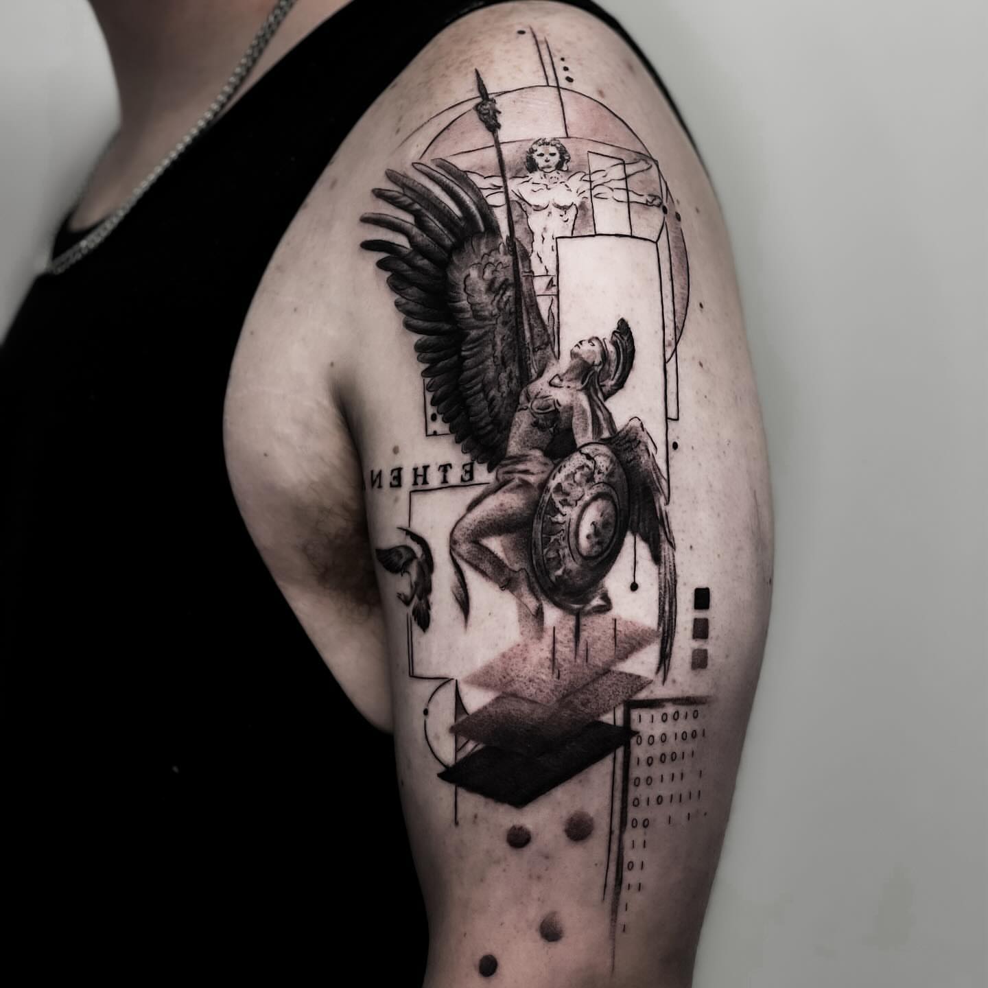 Winged angel with shield geometric tattoo on the shoulder by Banky