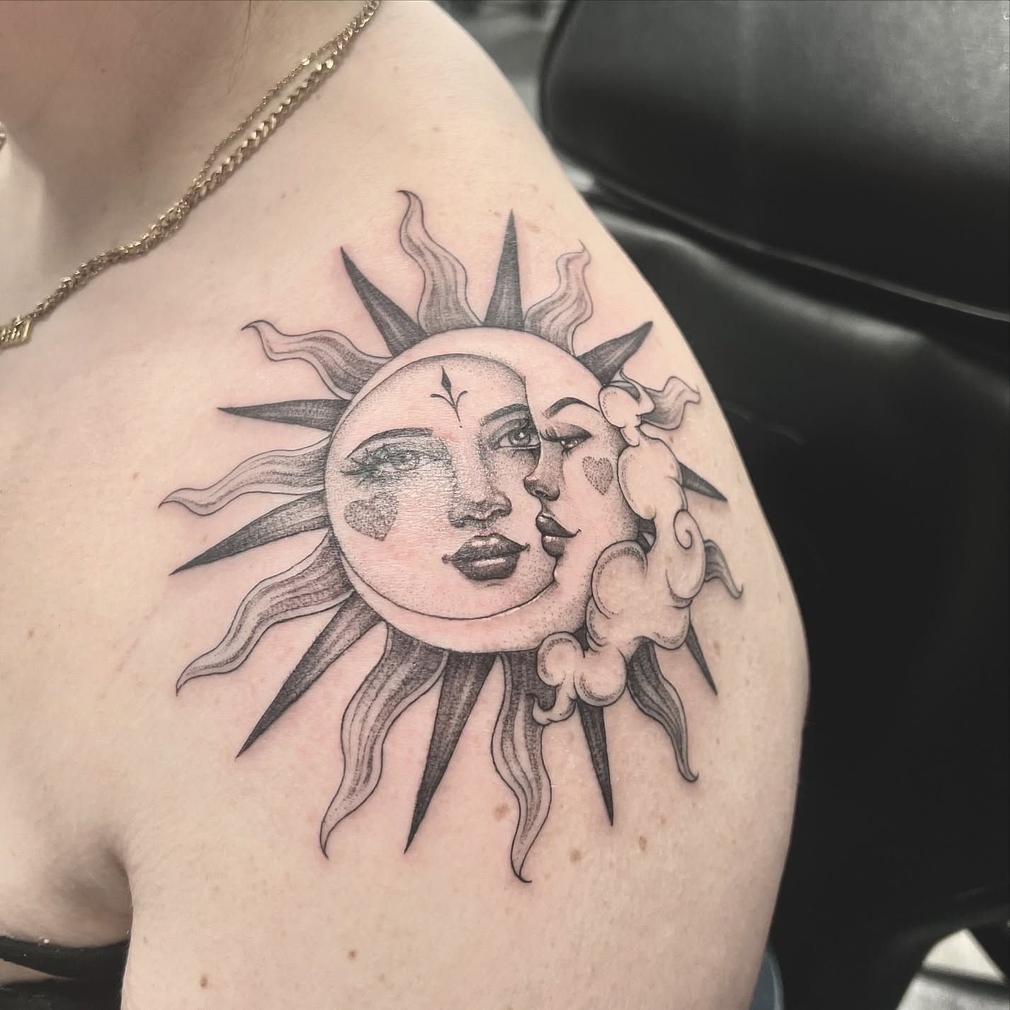 Sun and moon faces black and grey tattoo on the shoulder by Chelsea Speirs