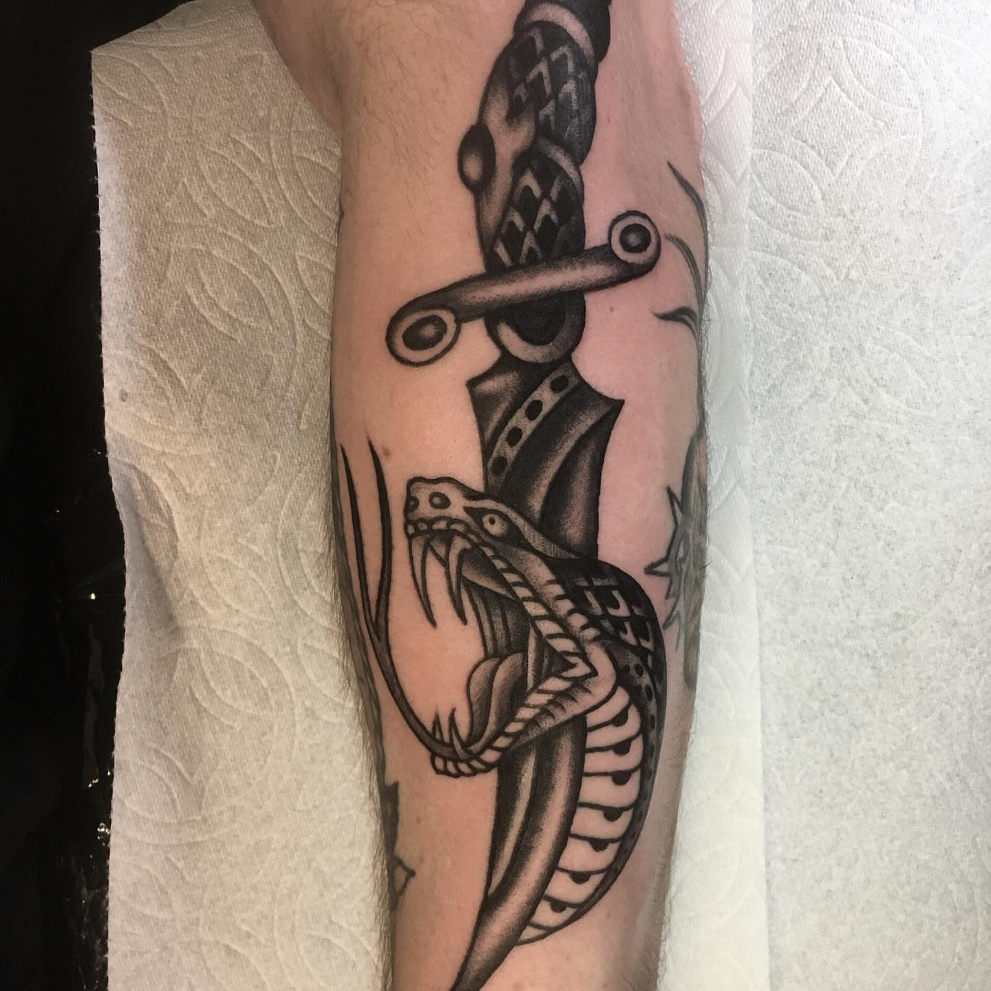 Snake and dagger black and grey tattoo on the forearm by Matt E.