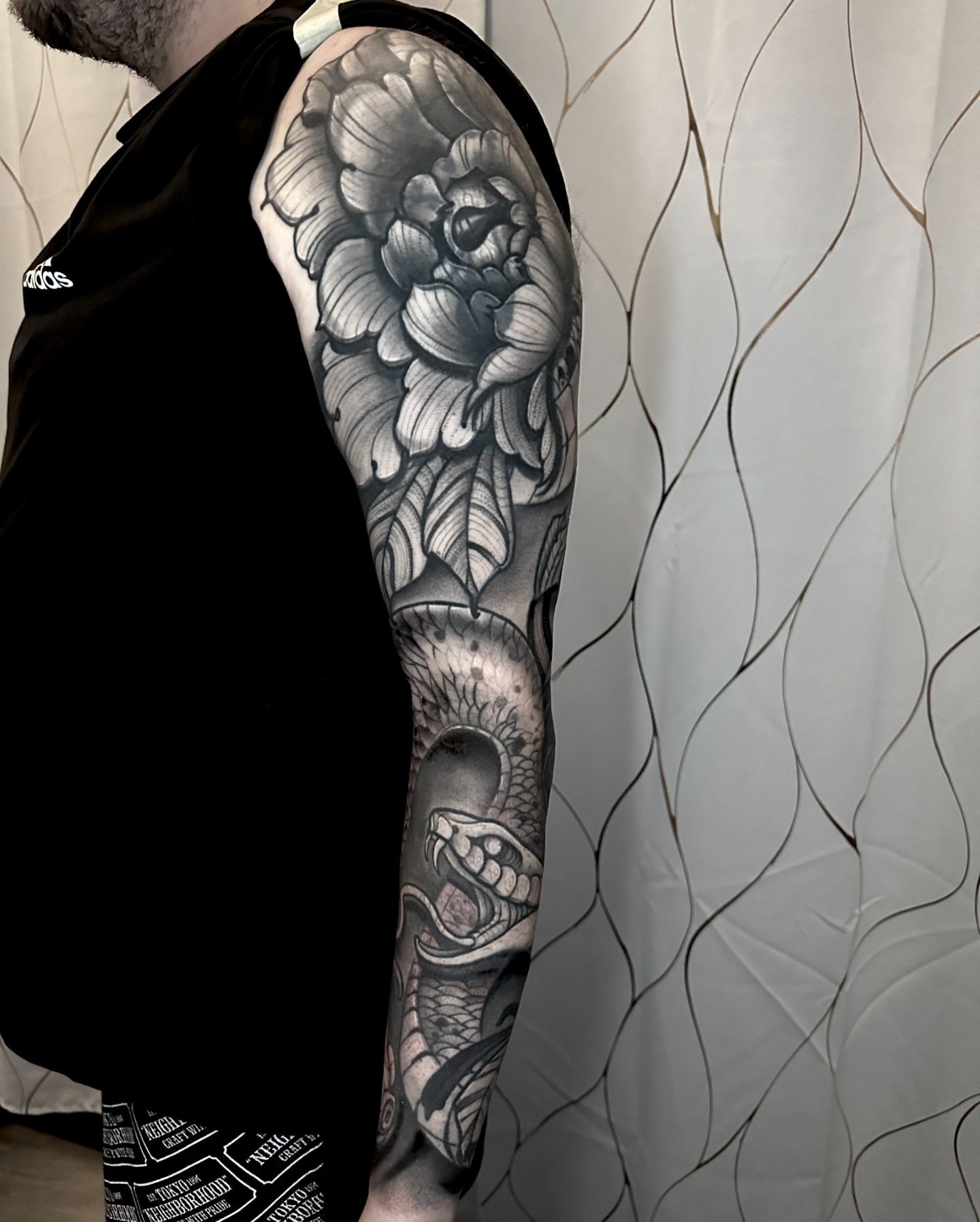 Snake and peony realism tattoo on the upper arm by Ty Pallotta, Austin, Texas