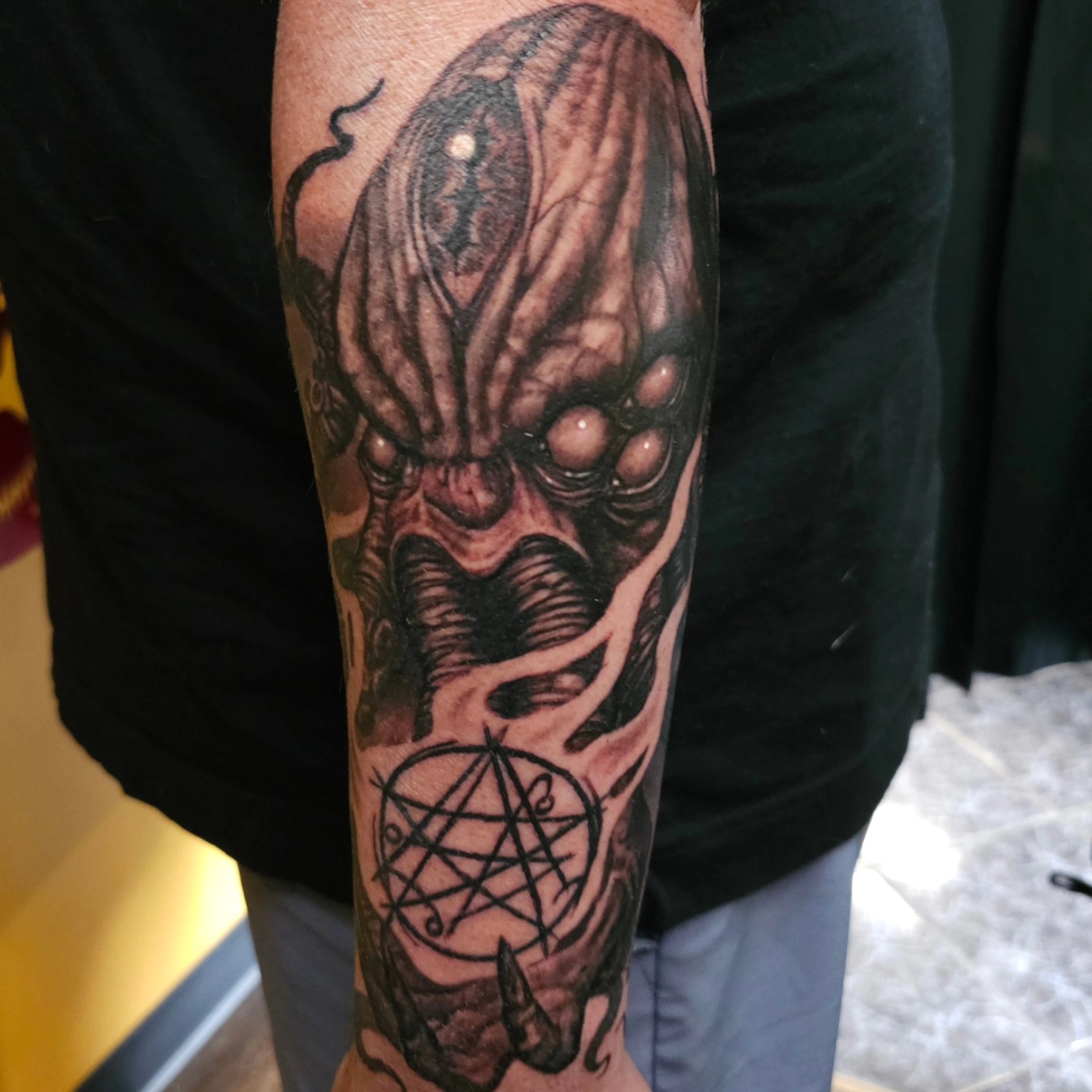Horror creature dark realism tattoo on the forearm by Dan Redding