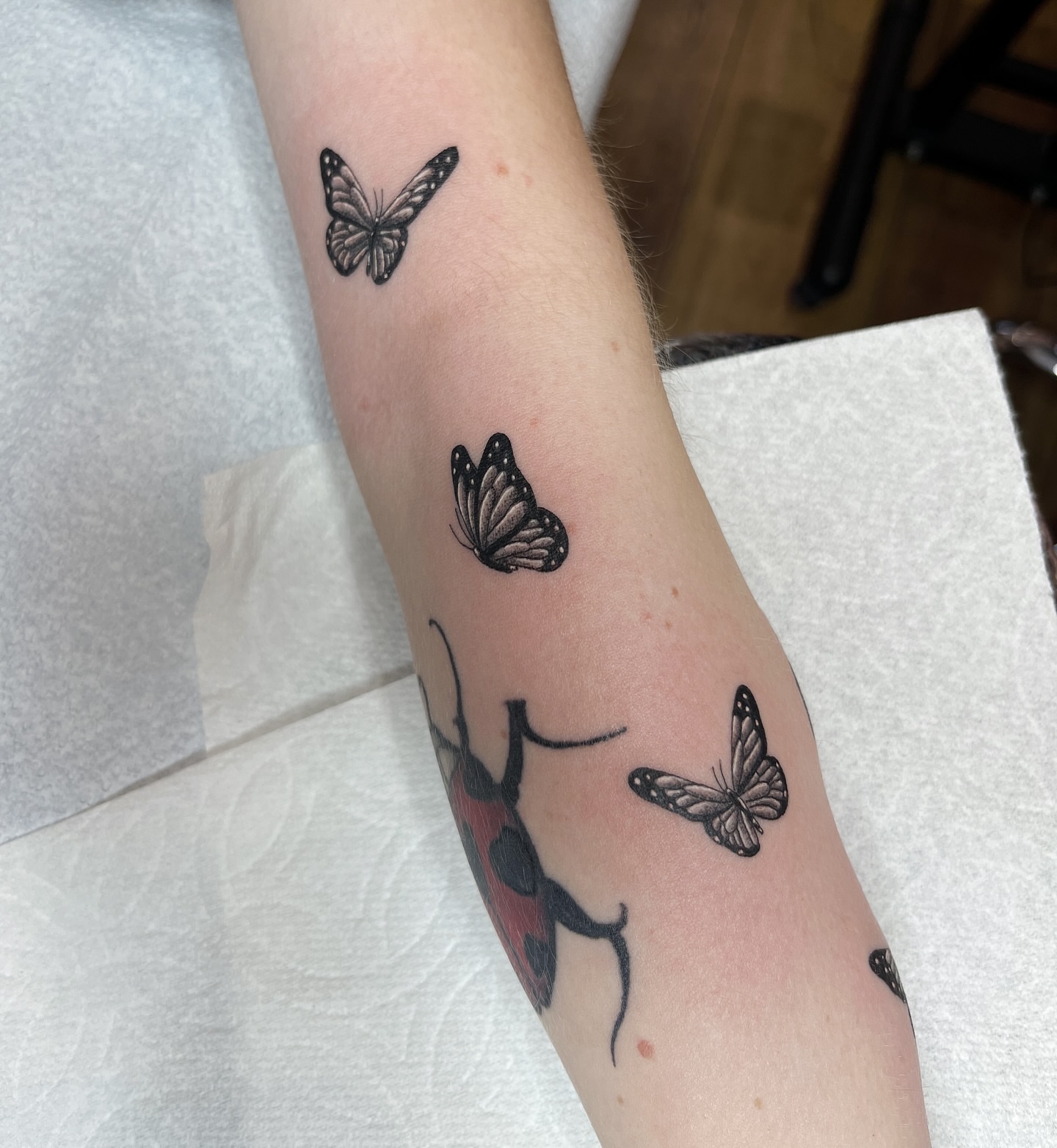 Fairy with butterflies black and grey tattoo on the forearm by Taylor Newton