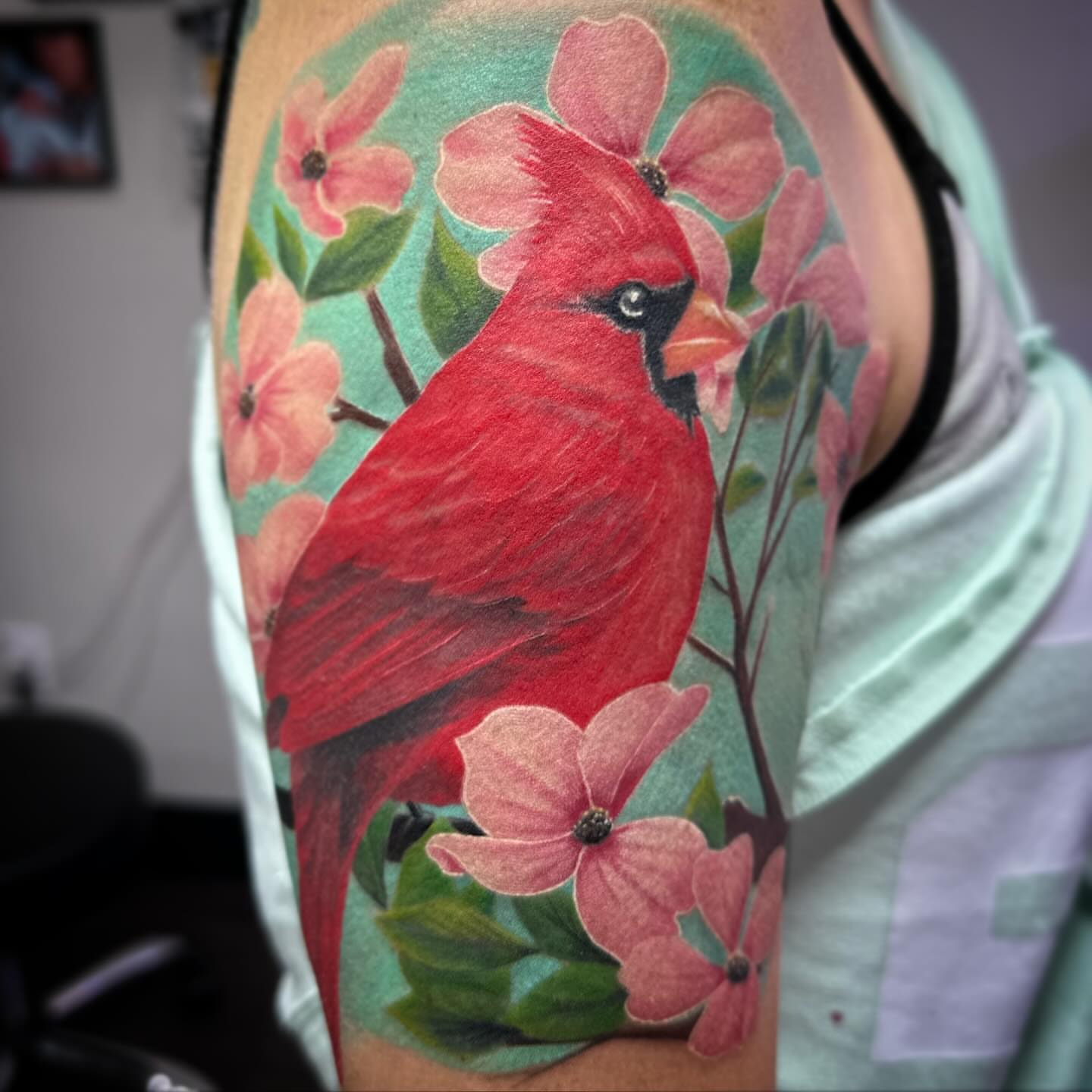 Cardinal bird realism tattoo on the upper arm by Oscar Arias