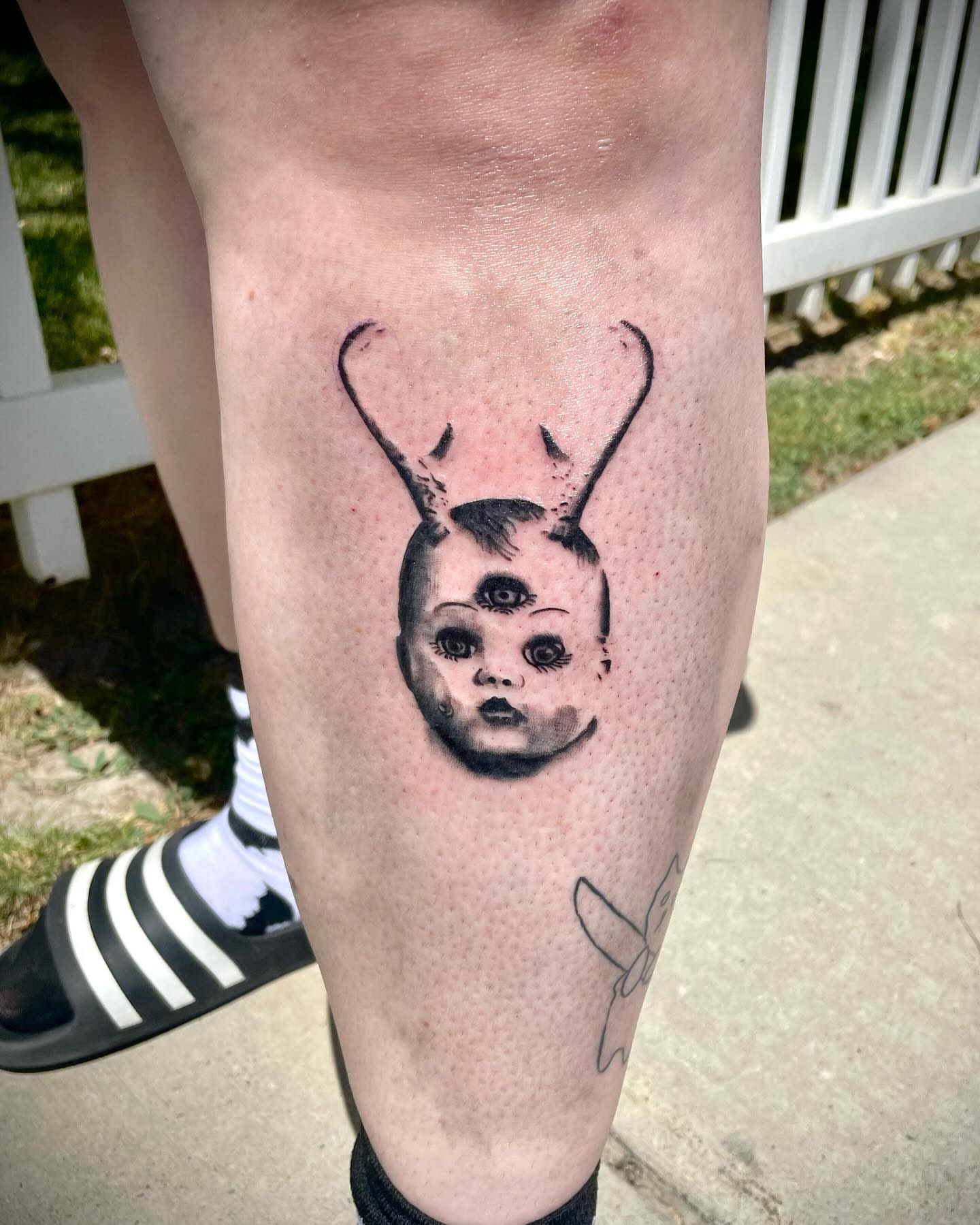 Doll head with rabbit ears dotwork tattoo on the calf by Kaylee 🗡️